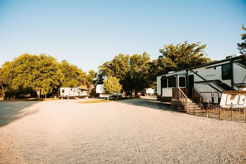 Southern view of a RV park with trees, mobile homes, and travel trailers.
