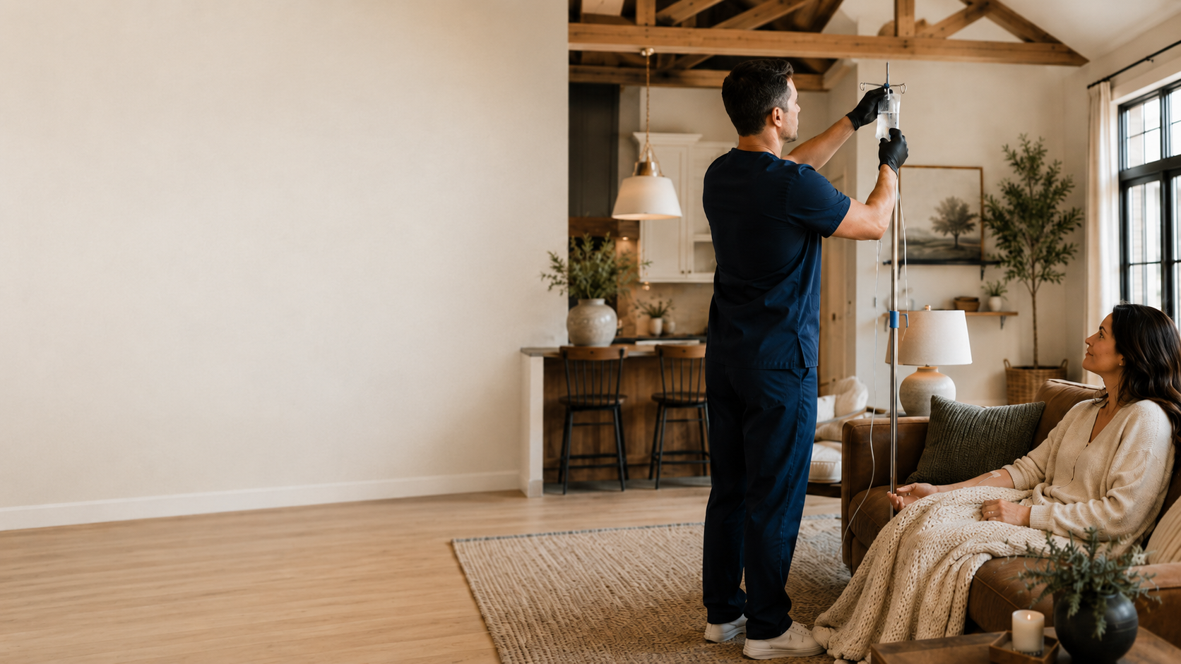 A nurse preparing an IV drip for a woman sitting on a sofa in a living room.
