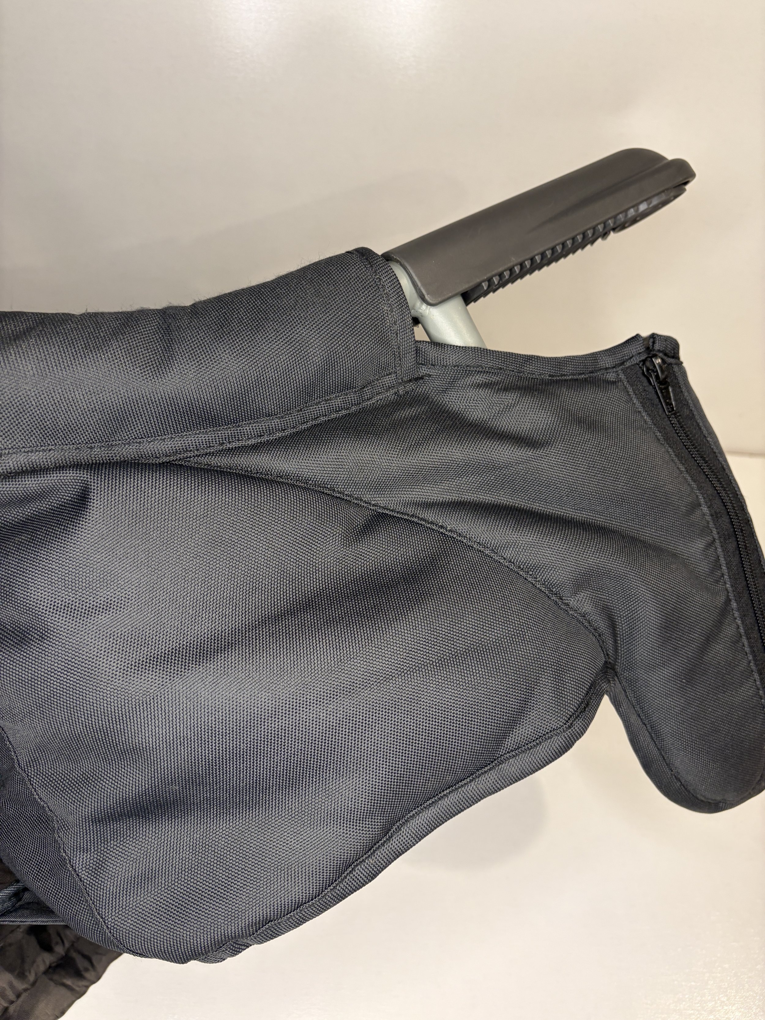 Black backpack with a zipper pocket on the side, and part of a handle or strap visible.