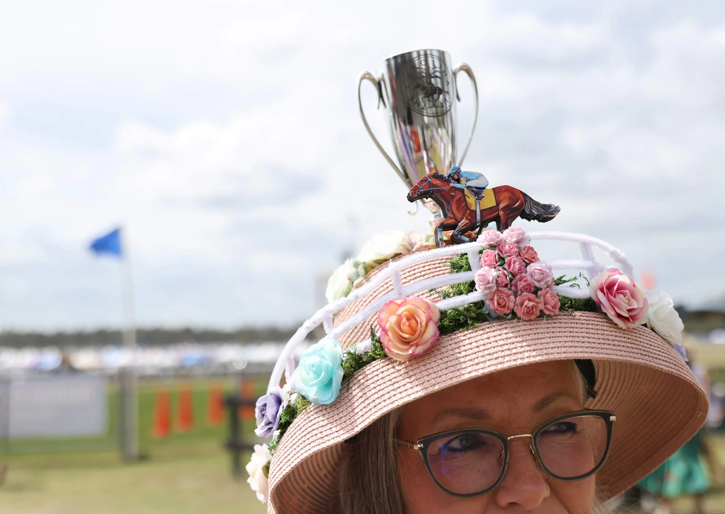 Mariel Padgett, from Charlotte, North Carolina, shows off her hat following the Hat and Fancy Pants Contest. She wanted the hat to look and spin like a carousel, “but it didn’t work out as planned” she said. Mariel her family have come to the cup for