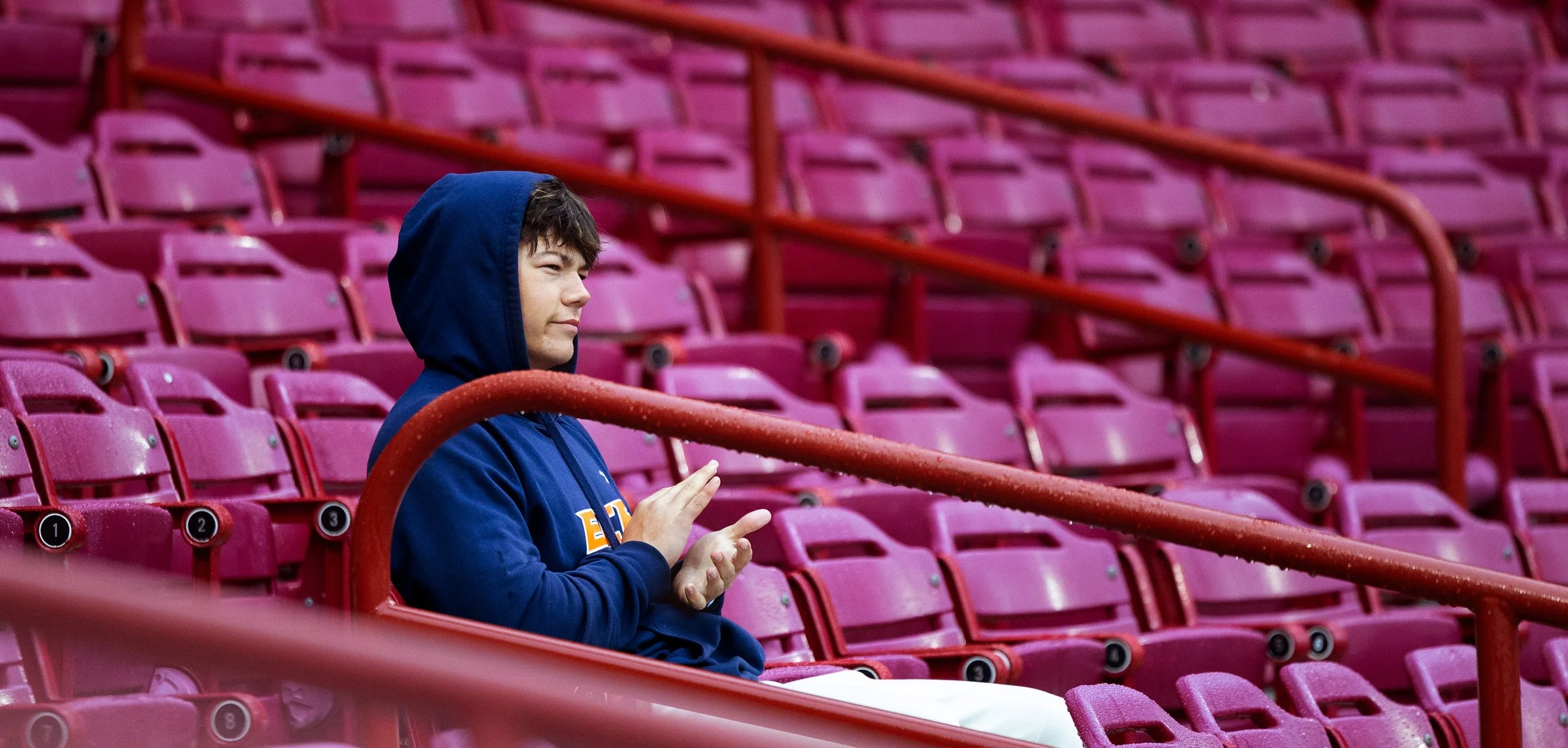 South Carolina Gamecock fan, Riley Furrow, 18, claps and frowns after a successful play by the opposing Queens baseball team on Feb. 24, 2025. Furrow came to the game with the baseball camp, Academy while driving through South Carolina to Alabama. 