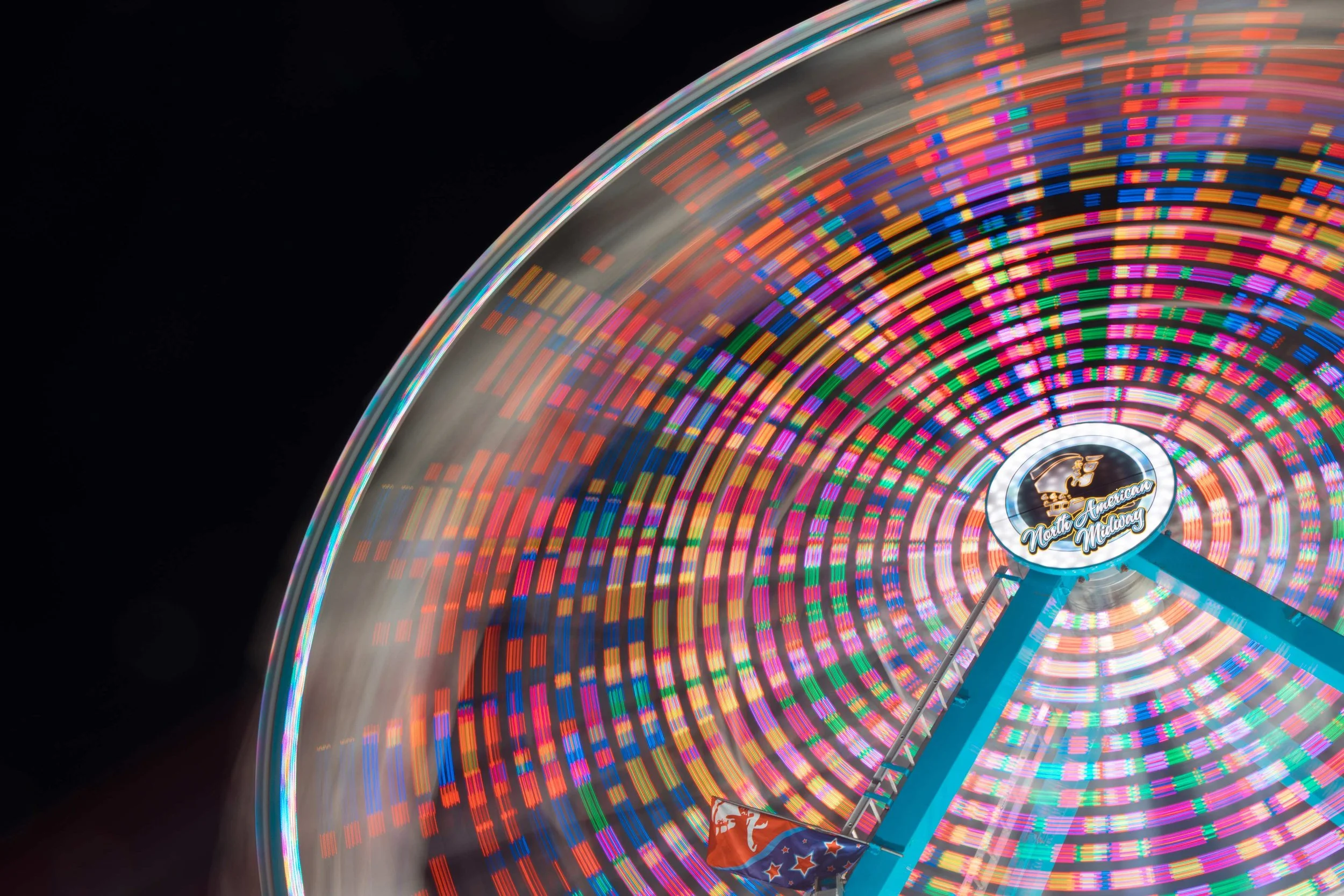 The North American Midway ferris wheel ride spins and flashes colors at the South Carolina State Fair on Oct. 12, 2024. The state fair welcomes almost 400,000 fairgoers each year. 
