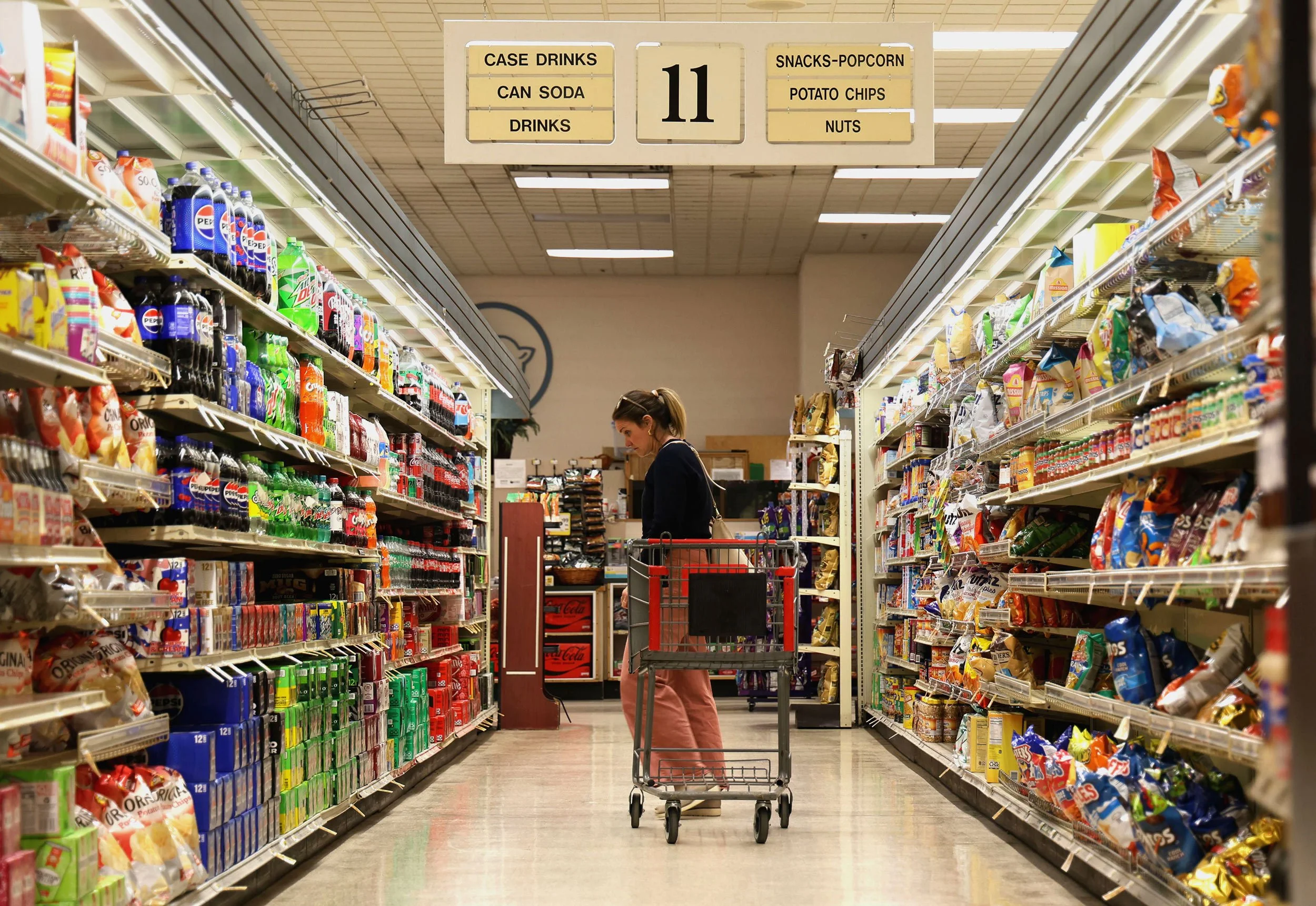 First-time shopper, Cassy Shea, browses the soda aisle while picking up items for a coworker at Piggly Wiggly’s Devine Street location on March 6, 2025 in Columbia, South Carolina. Shea, who works nearby, decided to visit the store before it closes. 
