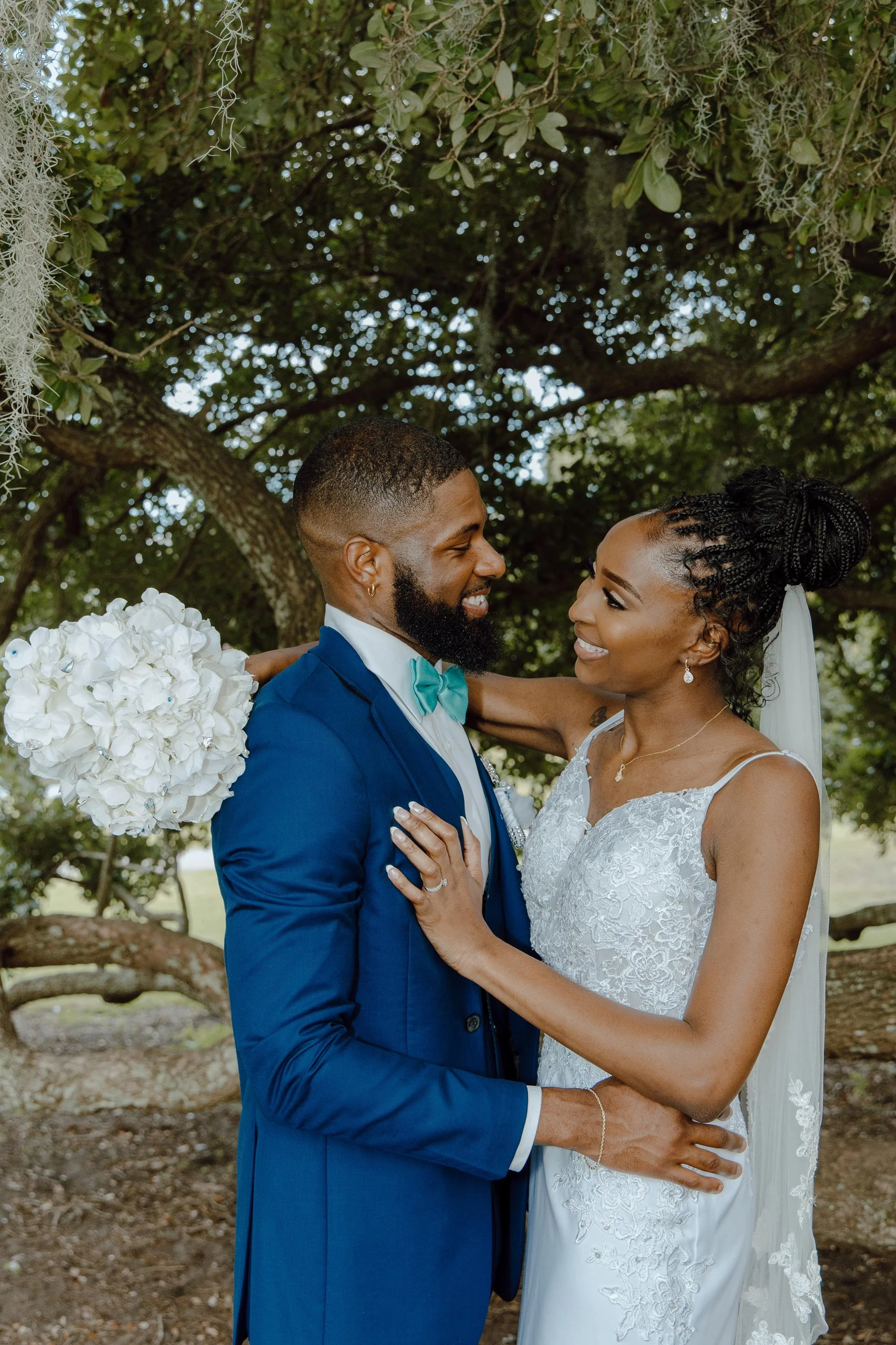 The Wilkins couple poses under a tree in Hampton Park in Charleston, S.C., on July 16, 2023, for wedding portraits.