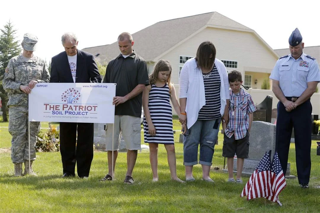 Left to right SFO Stesha Slates, Gary Robinson of The Patriot Soil Project, Sgt. Jeremy Langham, Marlee Eckert, 10, Tiffany Eckert, Myles Eckert, 9, and Lt. Col. Frank Dailey during a moment of silence for Sgt. Andy Eckert.