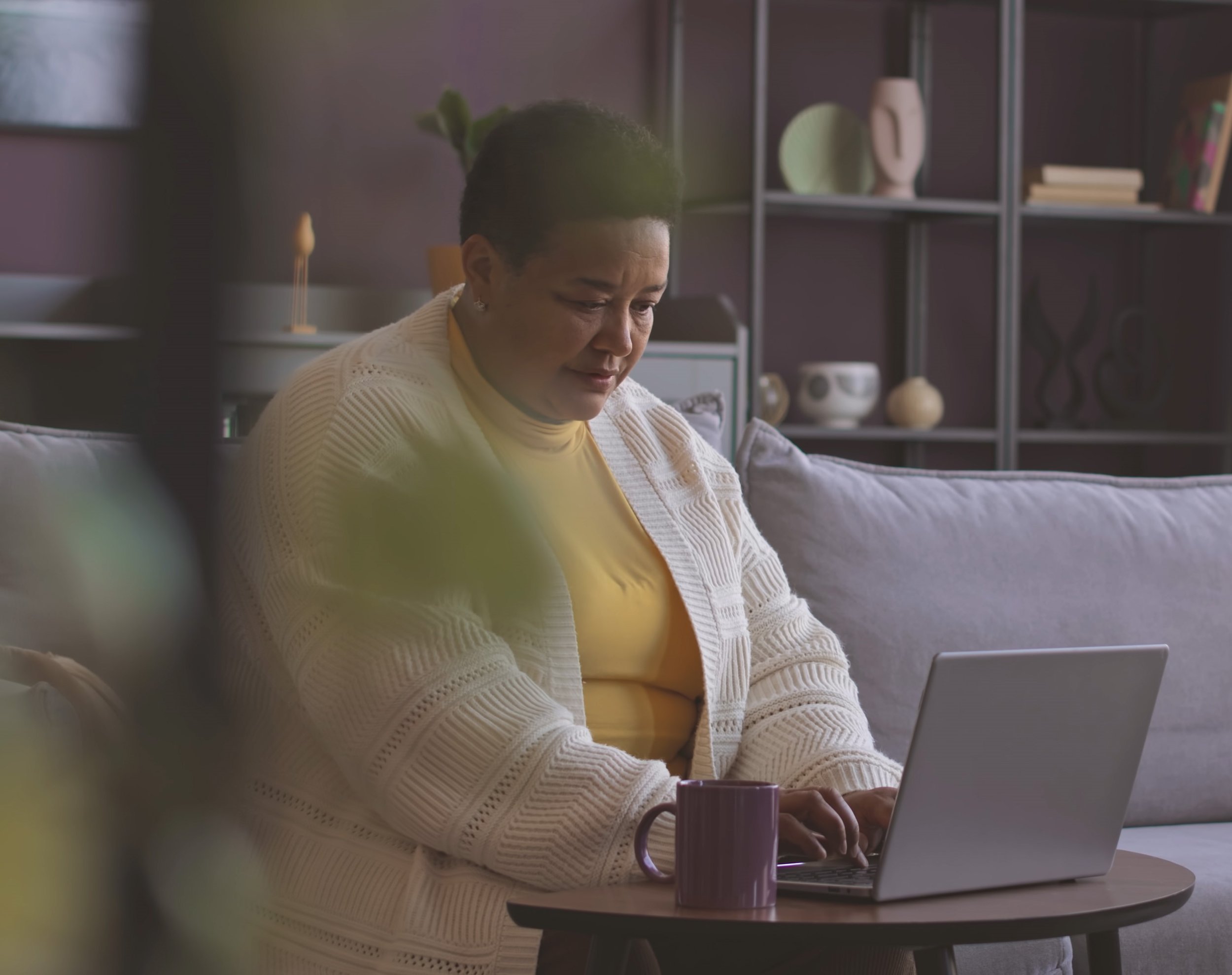 Femme assise qui lit des informations sur un ordinateur.