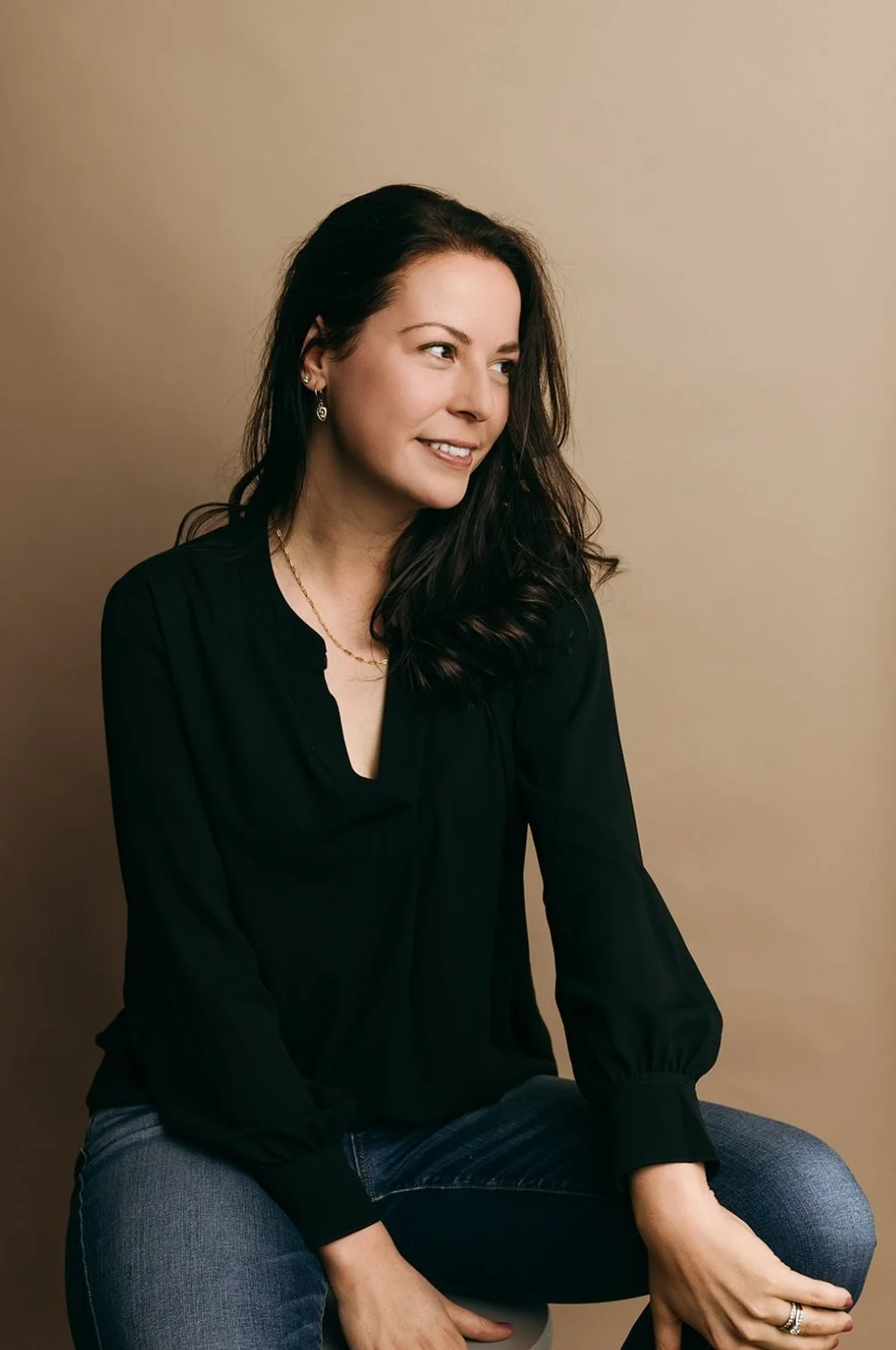 femme brune avec chemise noire qui sourit