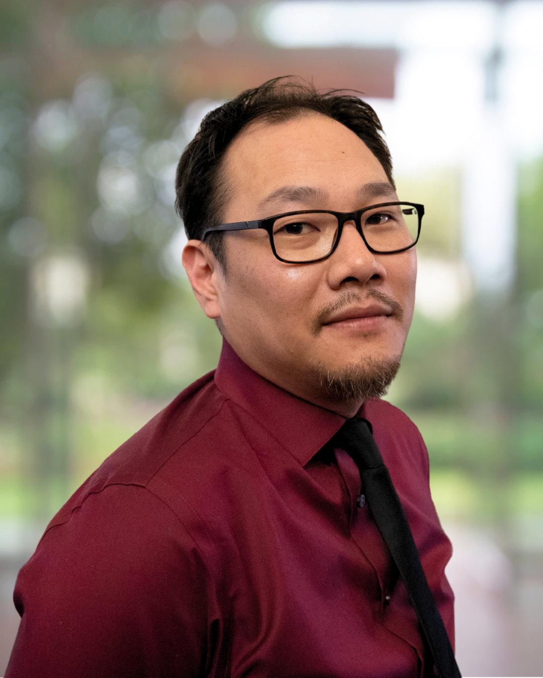 portrait de Jeremie grandbois, homme de type asiatique avec chemise rouge te lunette noire.