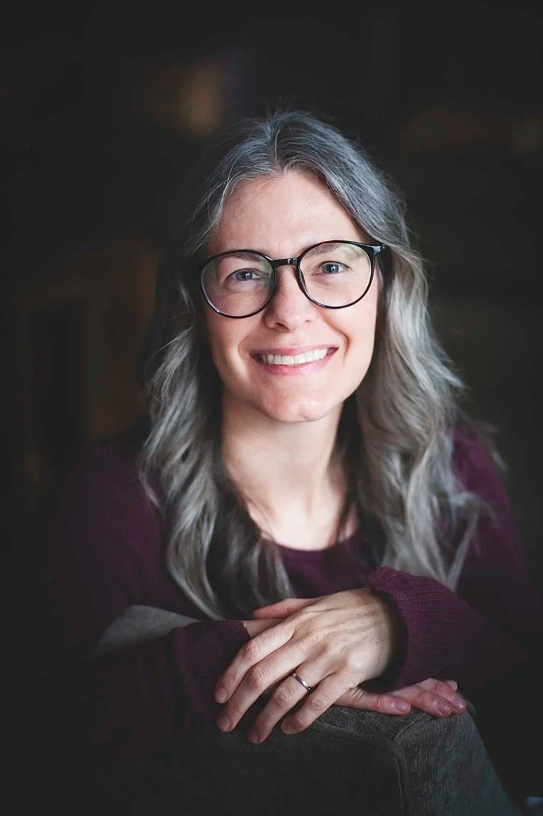 Portrait de Sarah West, femme cheveux gris avec lunette.