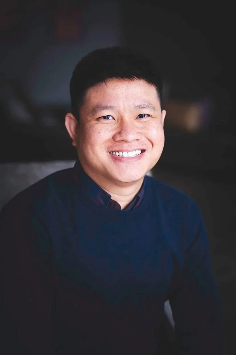 portrait de Francis Orasa, homme asiatique avec lunette et veste bleu