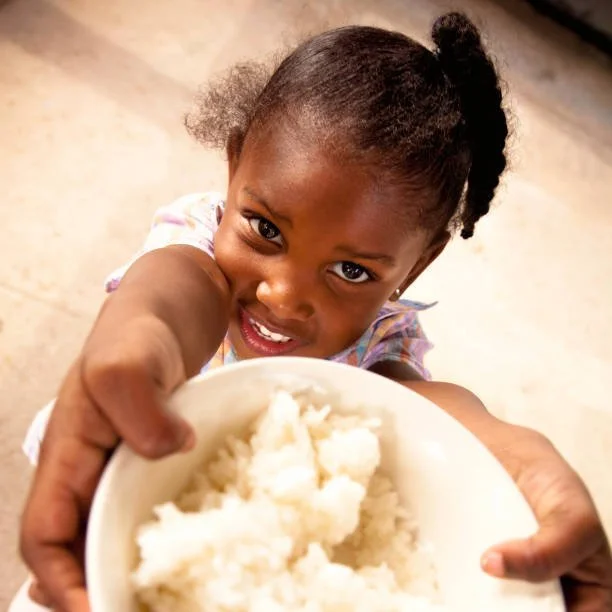 Child with a bowl of rice