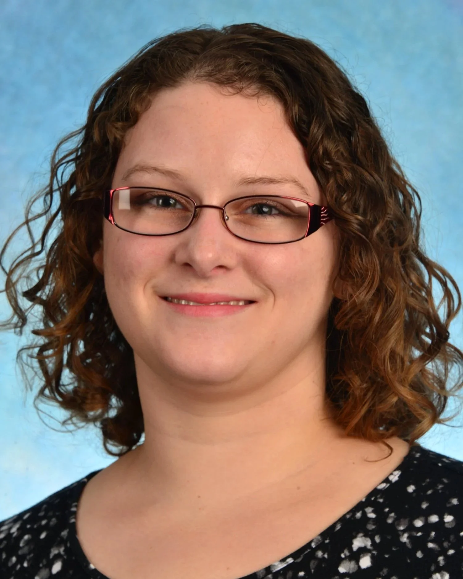 A professional headshot of Dr. Engle, a female with light-colored skin, curly brown hair, and glasses.
