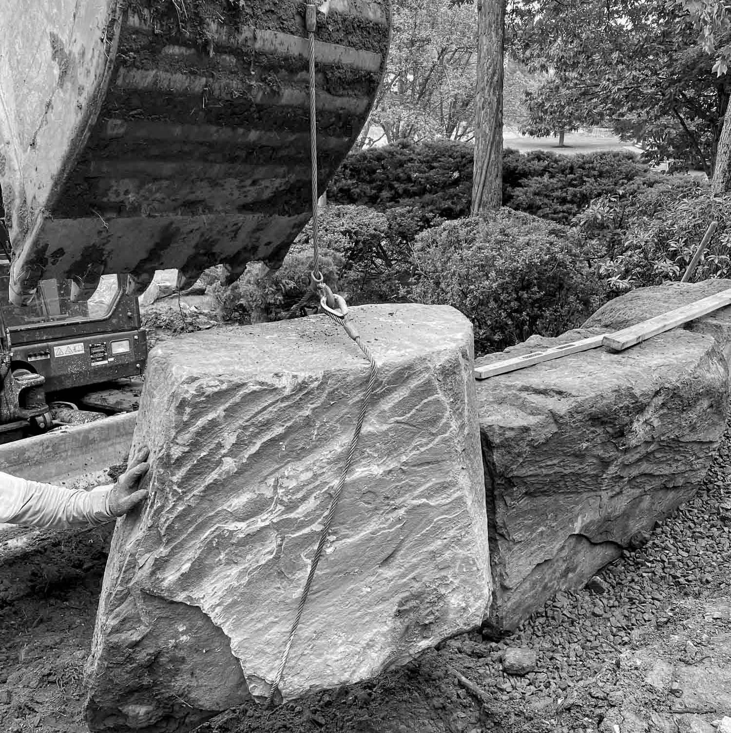 Using a wire rope sling to life a large rock for a Japanese retaining boulder wall