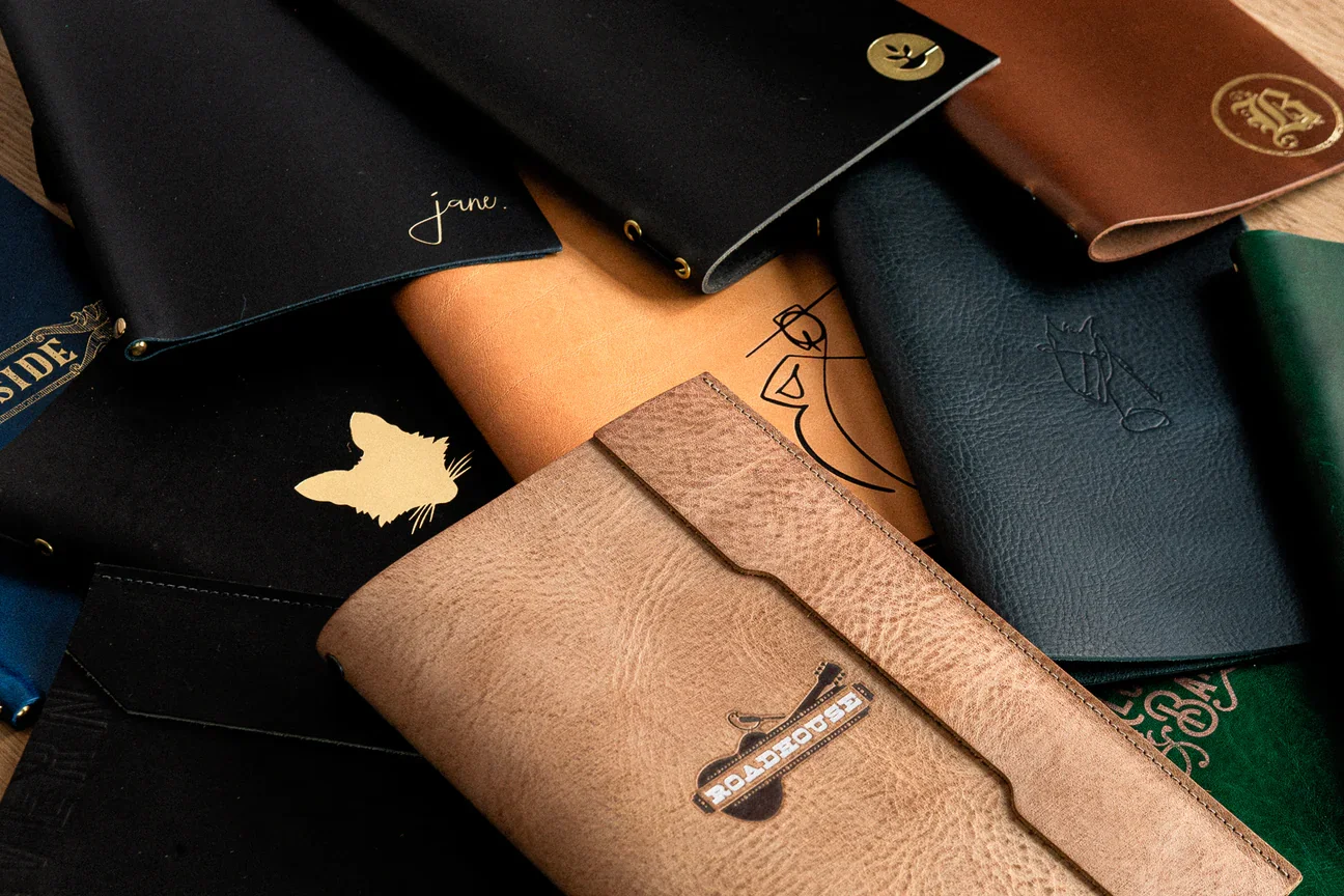 A stack of handcrafted leather menus showcase the color and texture variety possible with Lockeland Leather