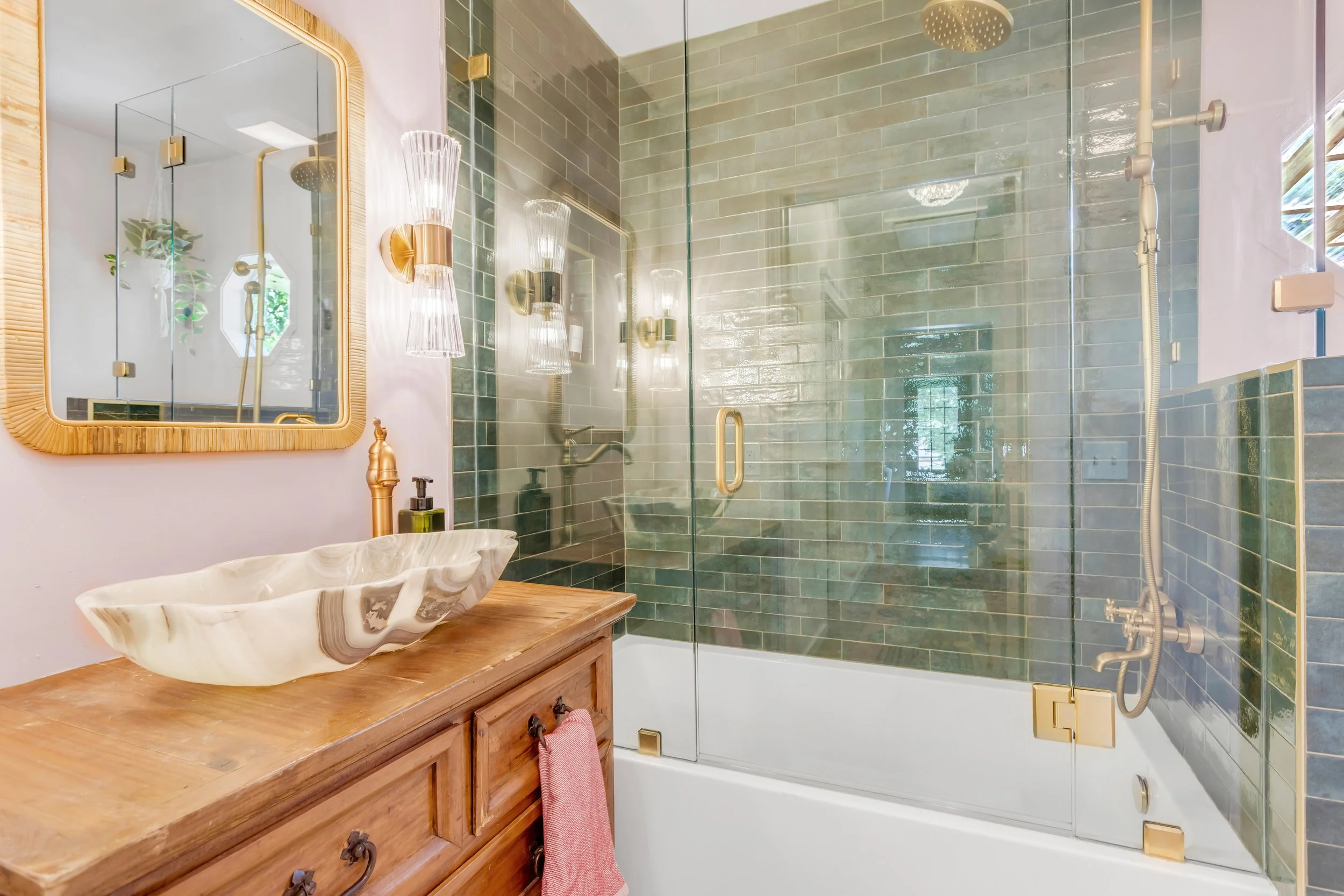 Fully remodeled bathroom with custom green tile, marble sink, bronze hardware and gorgeous blush pink paint.