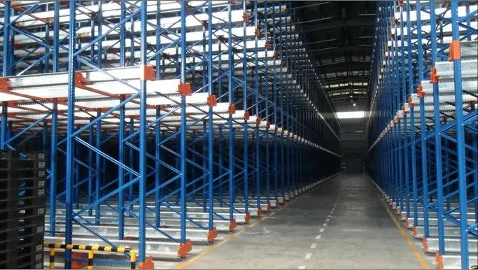 Empty warehouse storage racks with blue metal shelving and a central aisle.