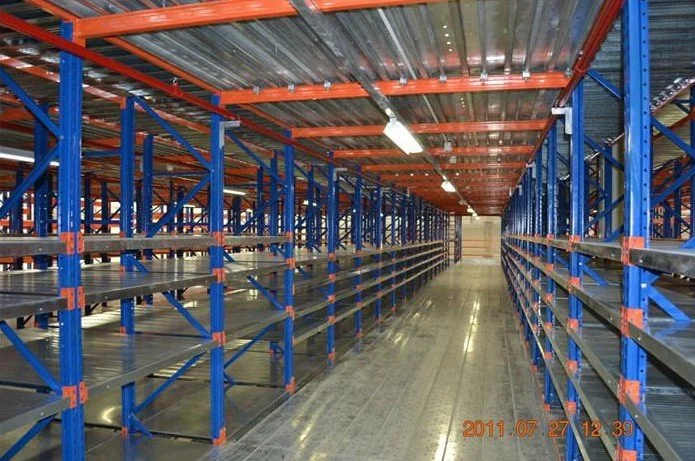Empty industrial storage shelves in a warehouse with metal flooring and overhead lighting.