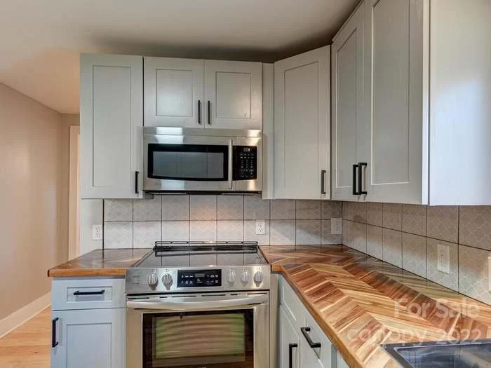 Kitchen view leading to laundry room and bathroom common areas 