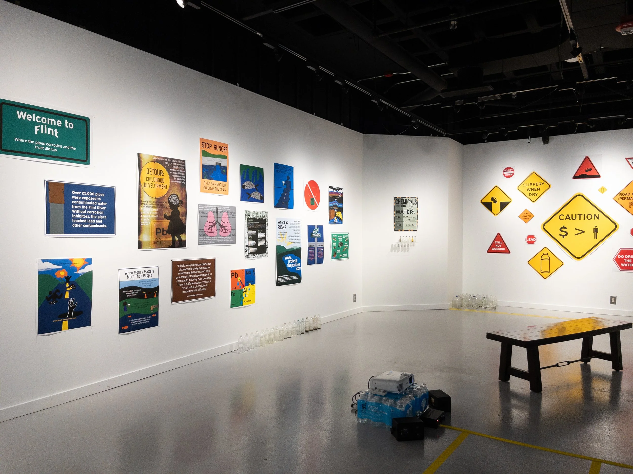 Picture of a section of the exhibition, showing more posters and water bottles.