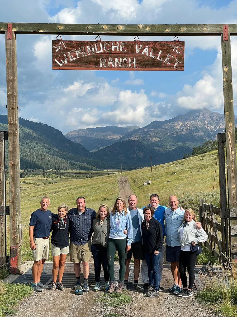 group of guests standing in front of the weminuche valley ranch gates