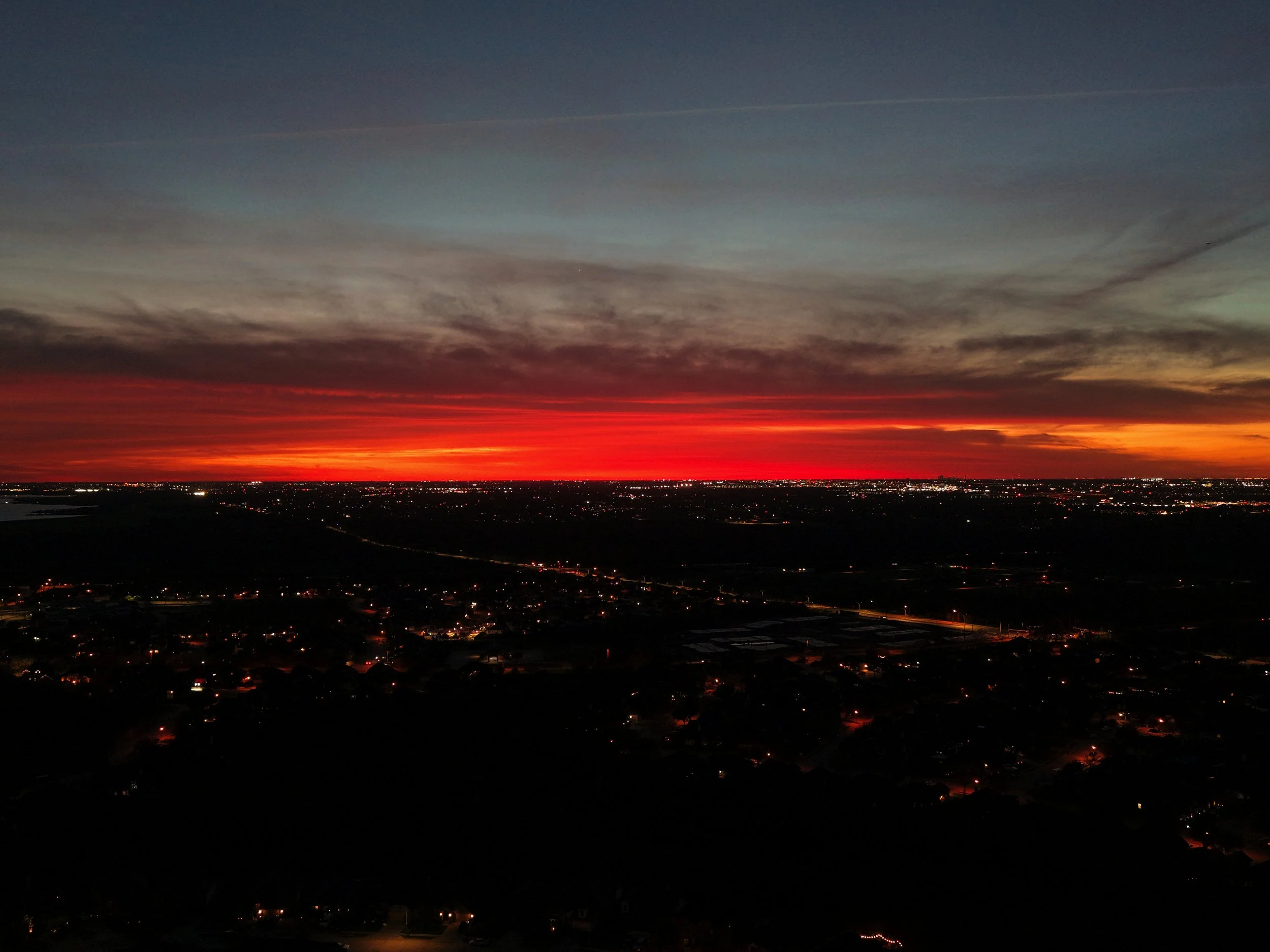 Sunset over a cityscape with colorful sky and city lights