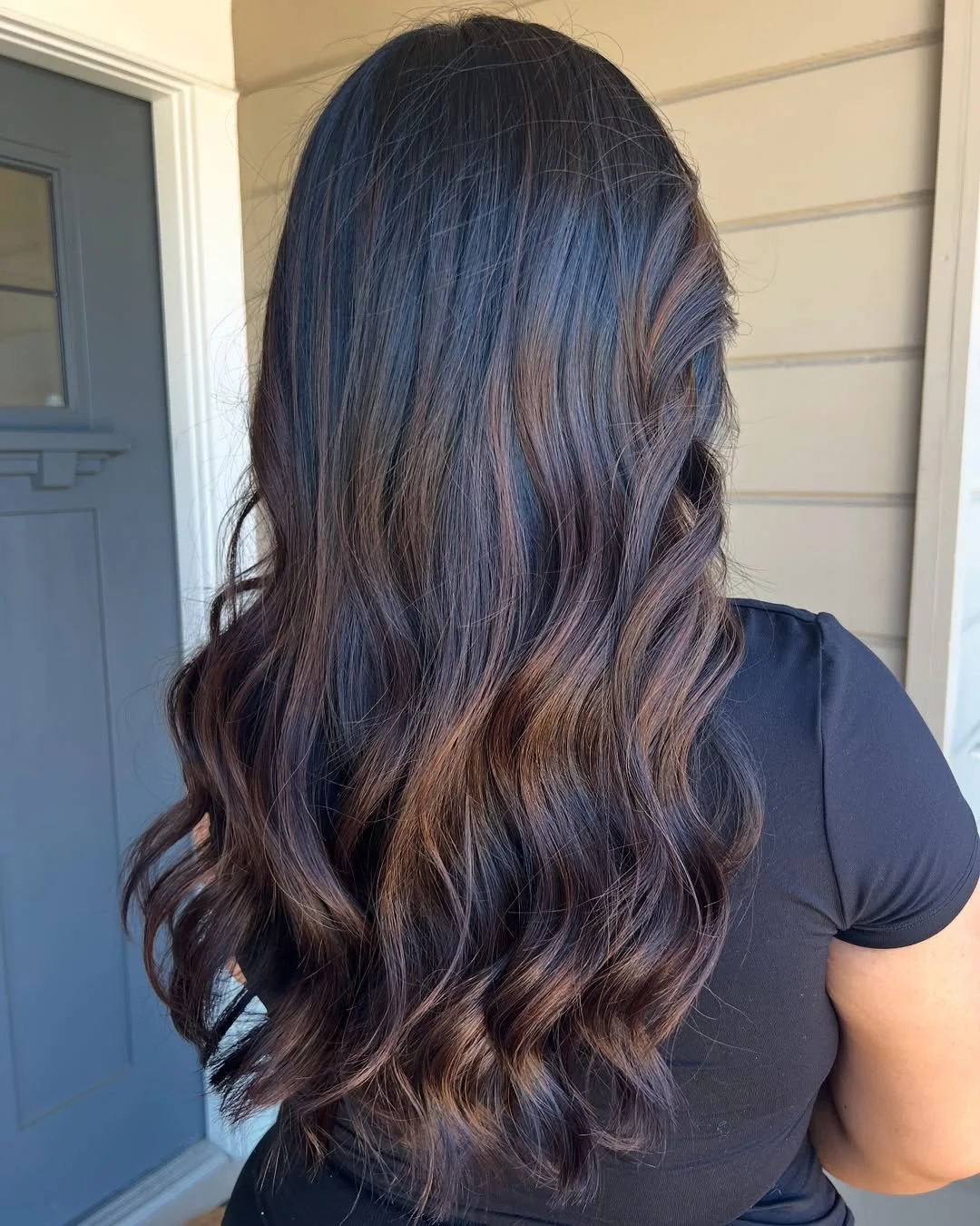Back view of a woman's long, wavy hair with shades of brown and subtle highlights. Hairstyle done by Caitlin Duffy Hairstylist at Bolt Collective Hair Salon in Pleasanton, CA.