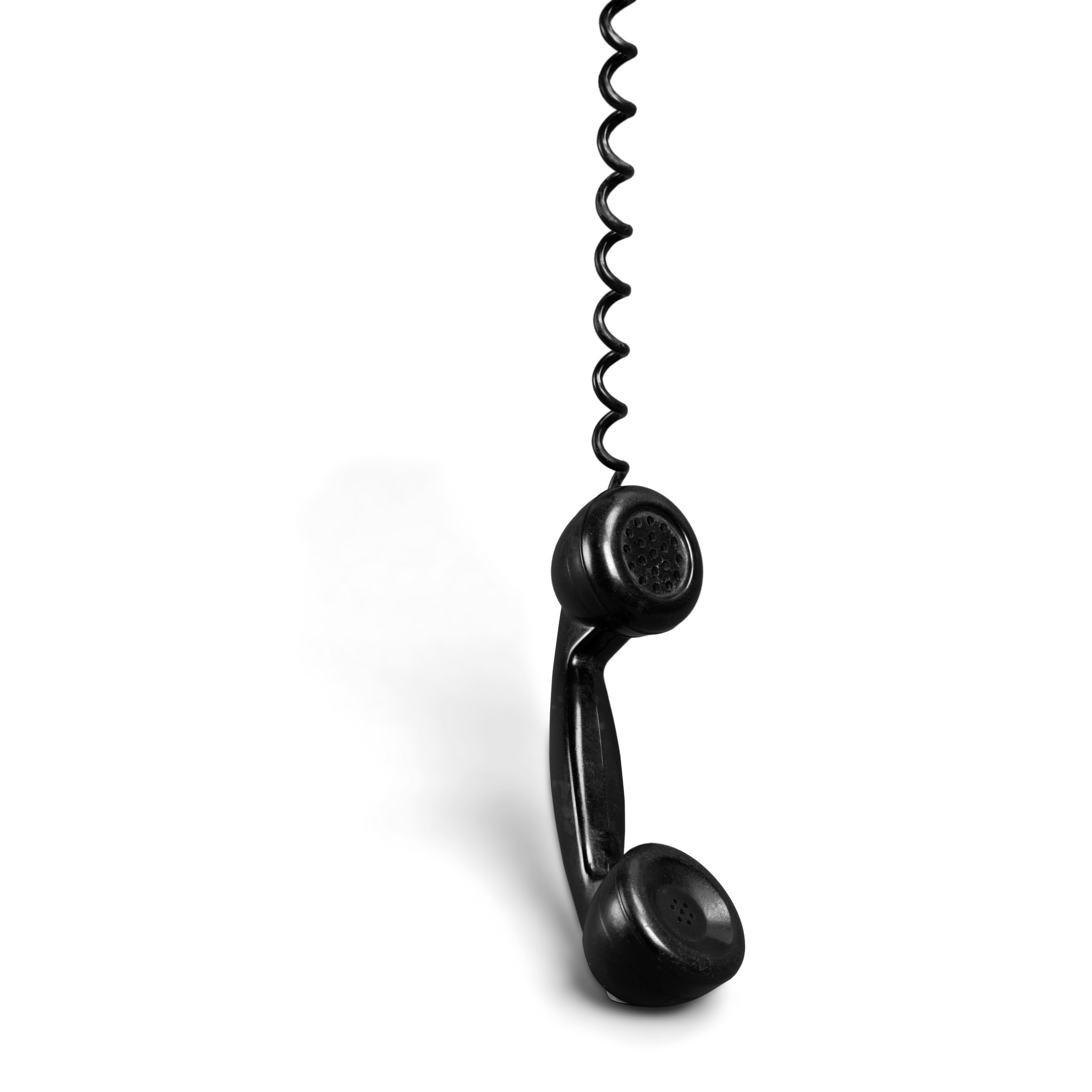 Black vintage telephone handset hanging on a stand.