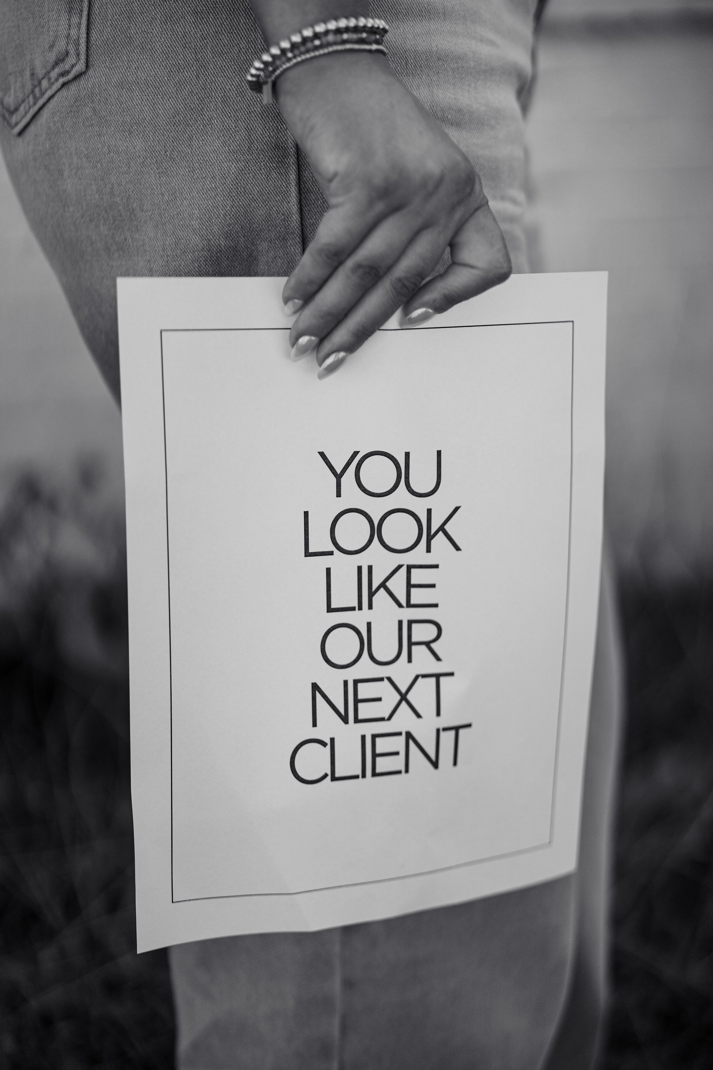 Person holding a paper with the text "You look like our next client".