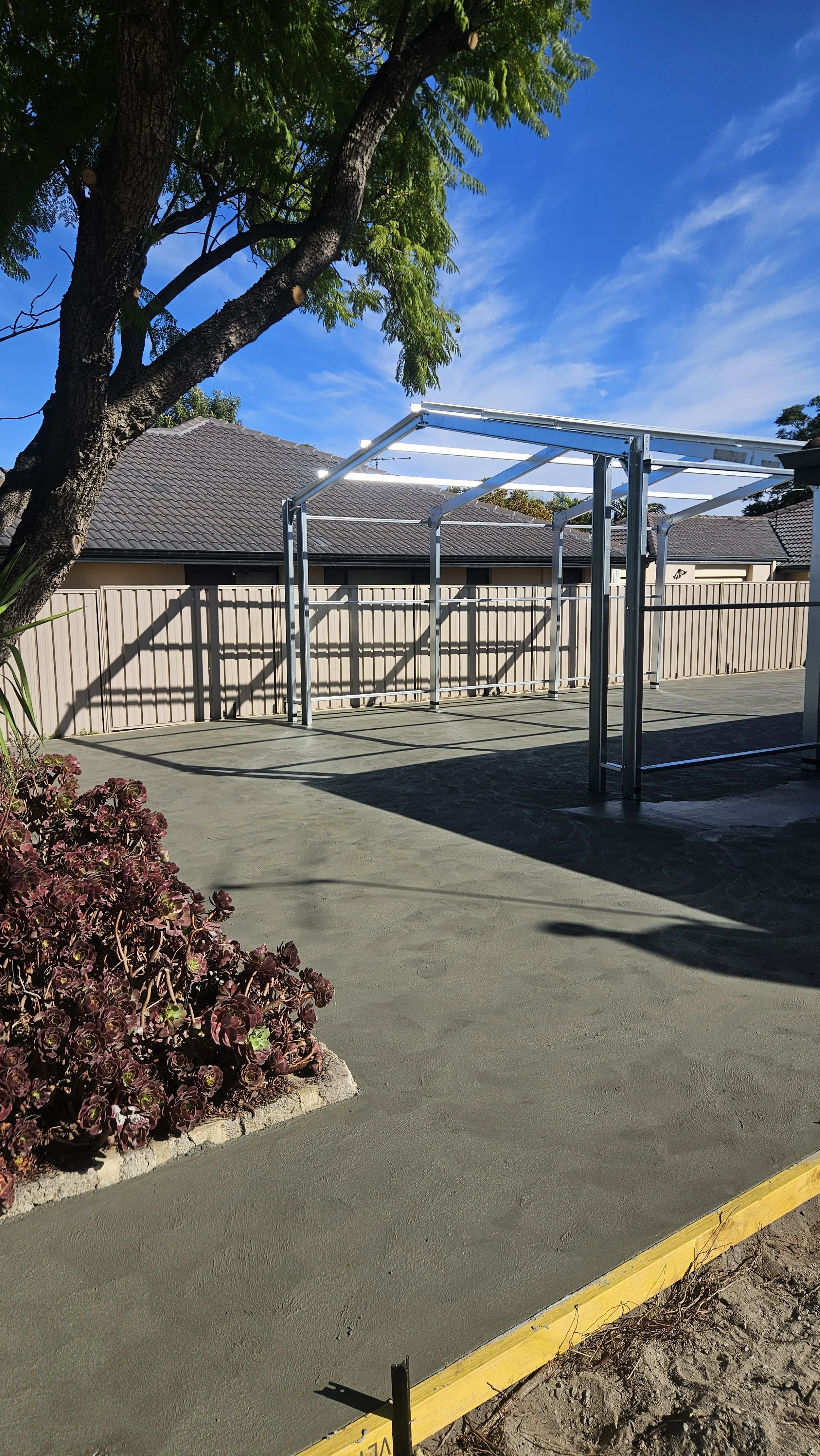 Grey concrete driveway and crossover and surrounds in Morley