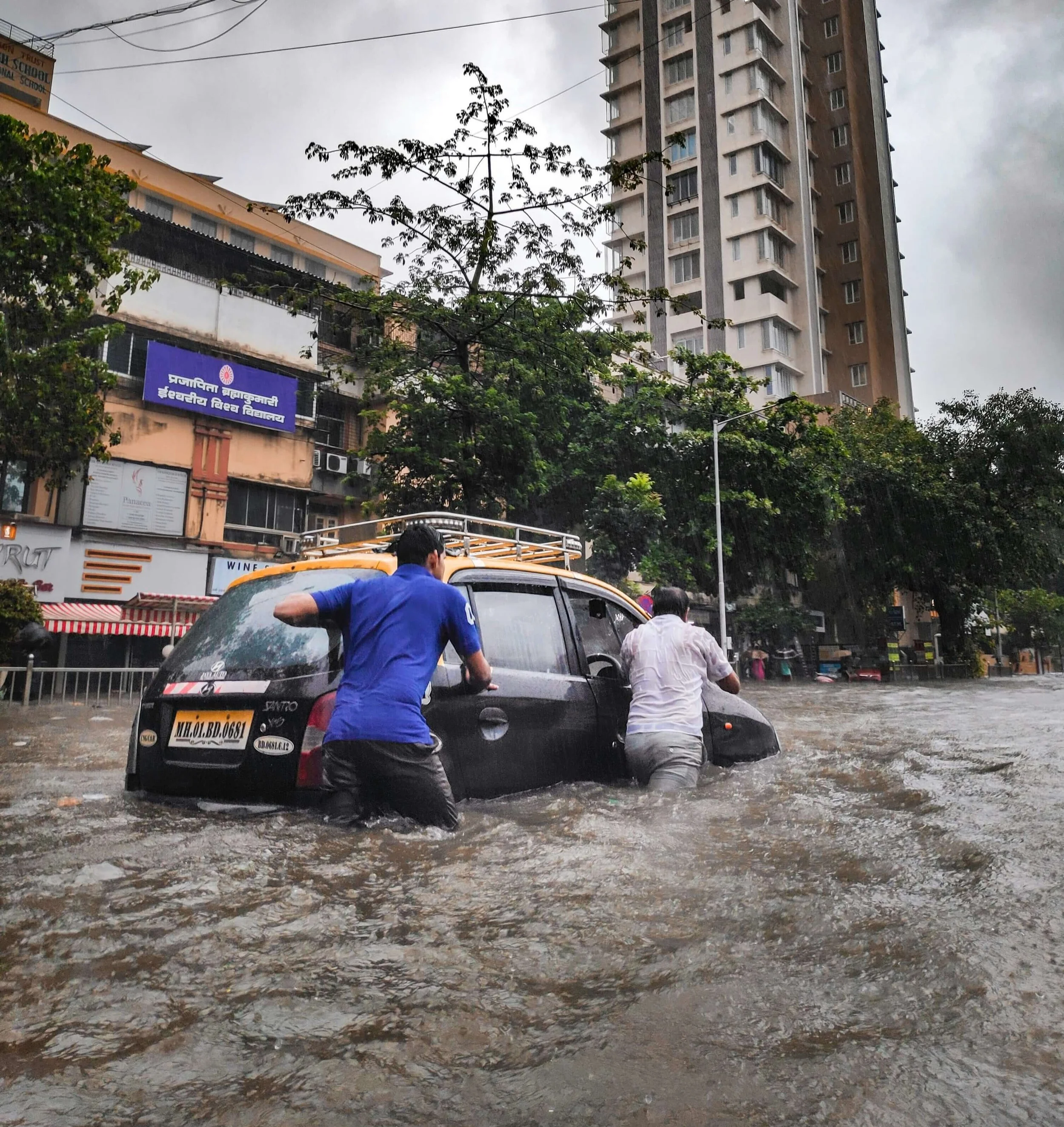 People push their taxi through a flooded street in Mumbai.