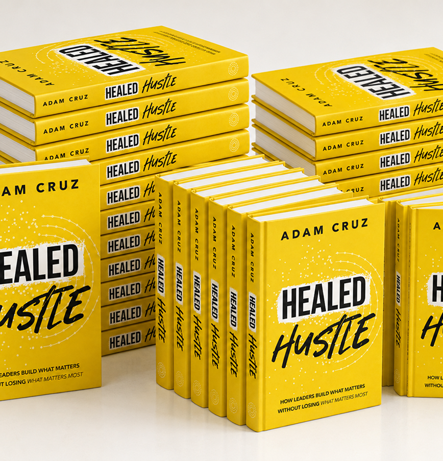 Multiple copies of the book titled 'Healed Hustle' by Adam Cruz arranged on a white surface with a yellow and white cover design.