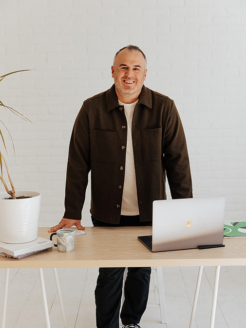 Adam Cruz standing behind desk