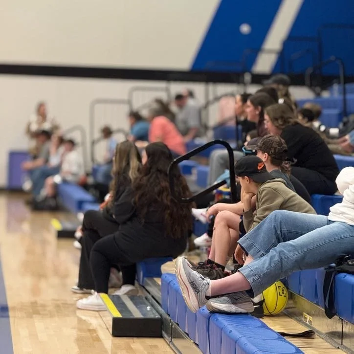 Spectators seated in gym stands watching alumni basketball tournament in Amity Oregon during organized community sports event