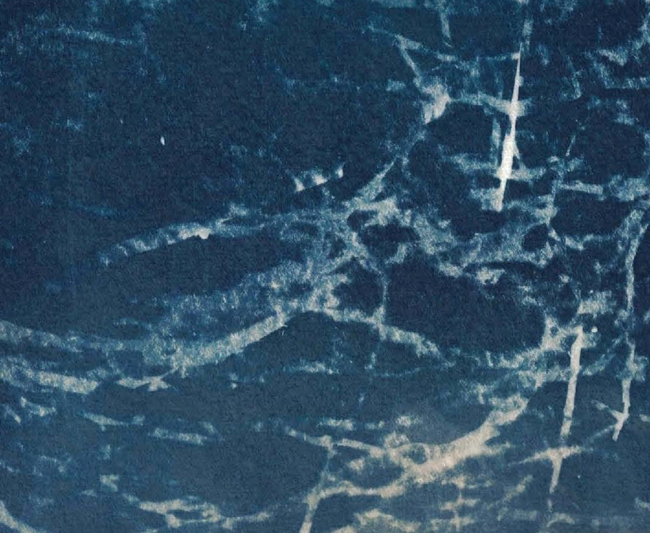 Close-up of a snowy, icy landscape with visible cracks and textured patterns on the surface.