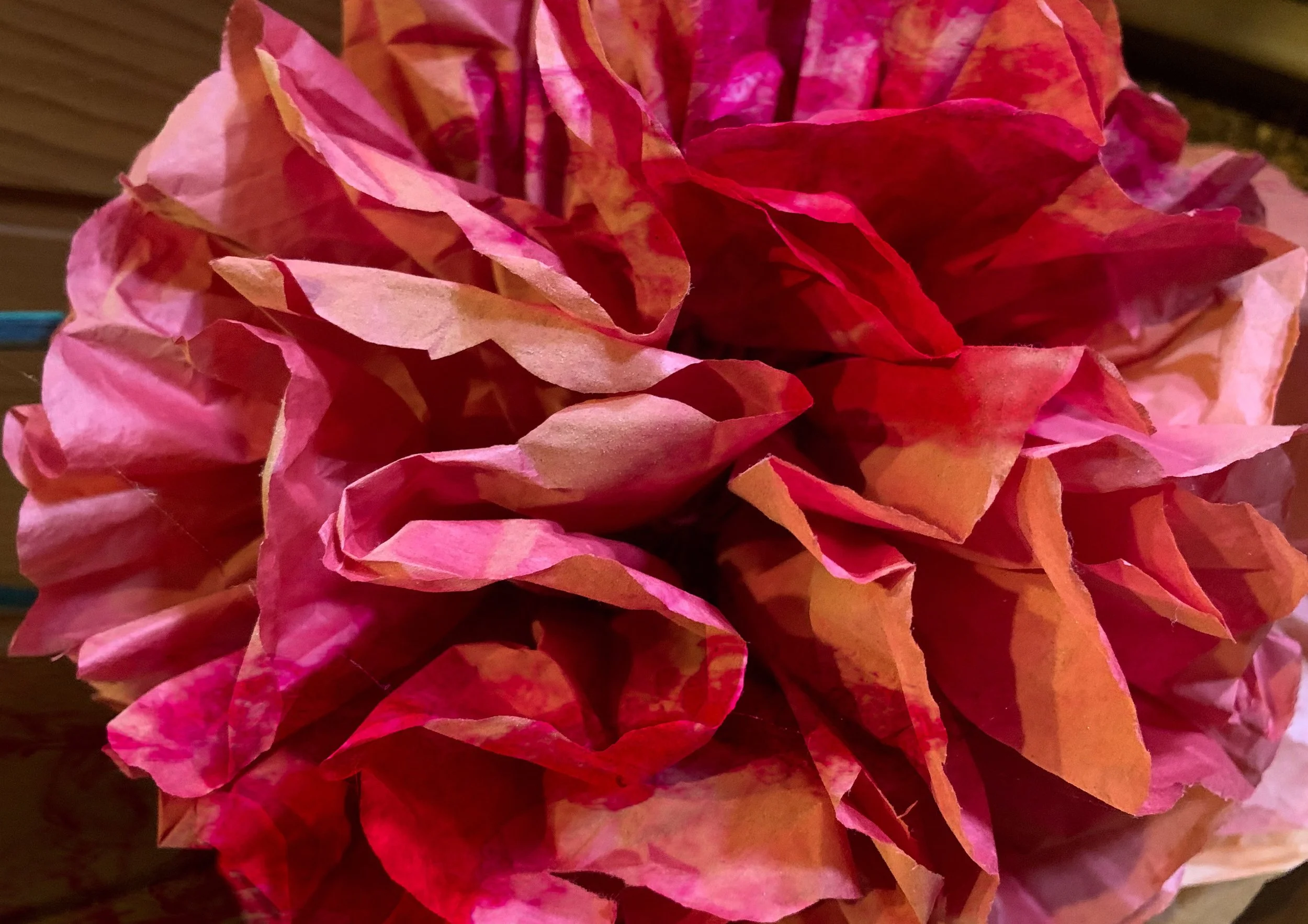 Close-up of pink and red crumpled tissue paper or paper flowers.
