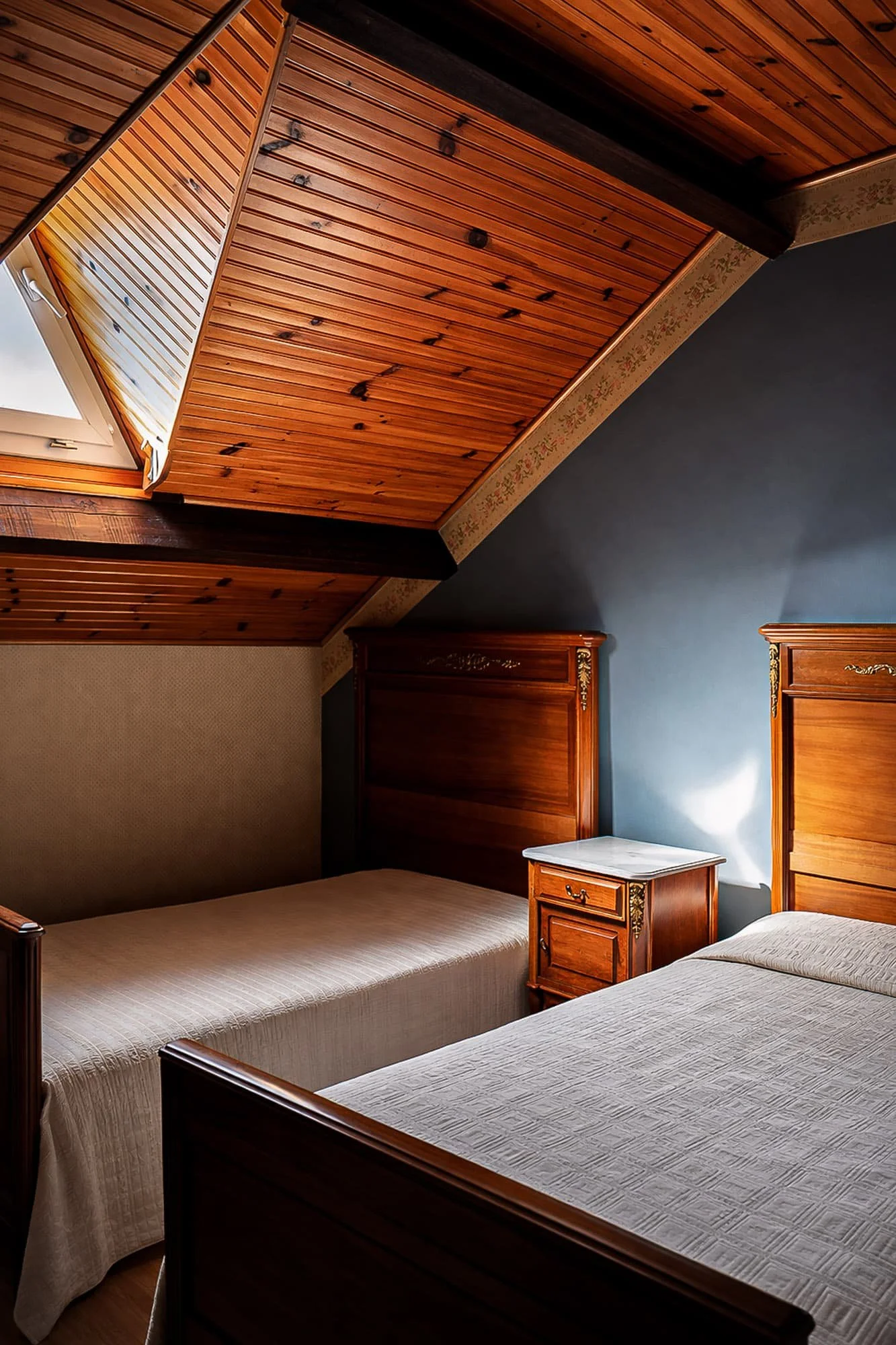 Photographie d’une chambre mansardée avec plafond en bois réalisée pour valoriser l’ambiance d’un intérieur.