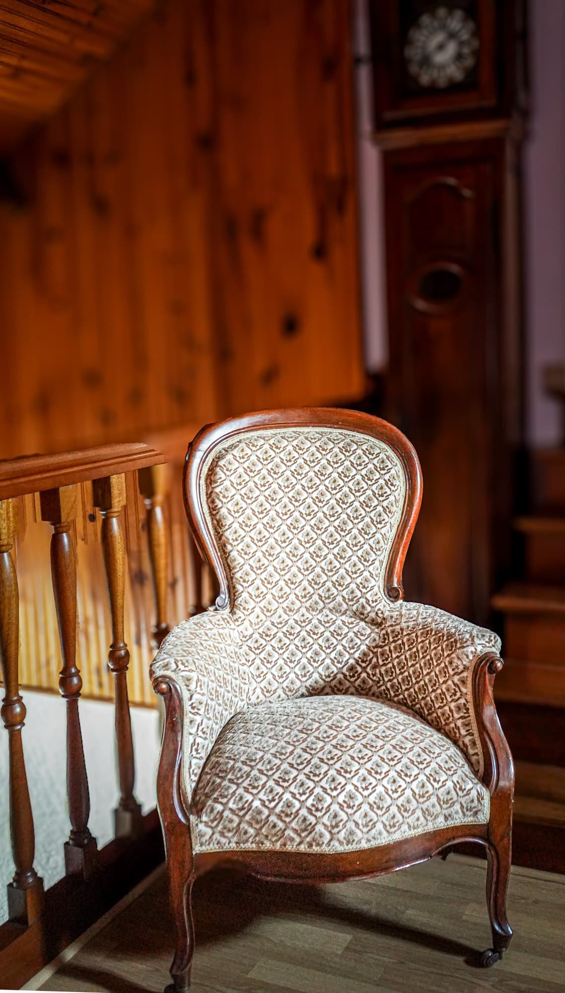 Photographie d’un fauteuil ancien dans un intérieur rustique réalisée pour valoriser l’ambiance d’un lieu dans une communication visuelle.
