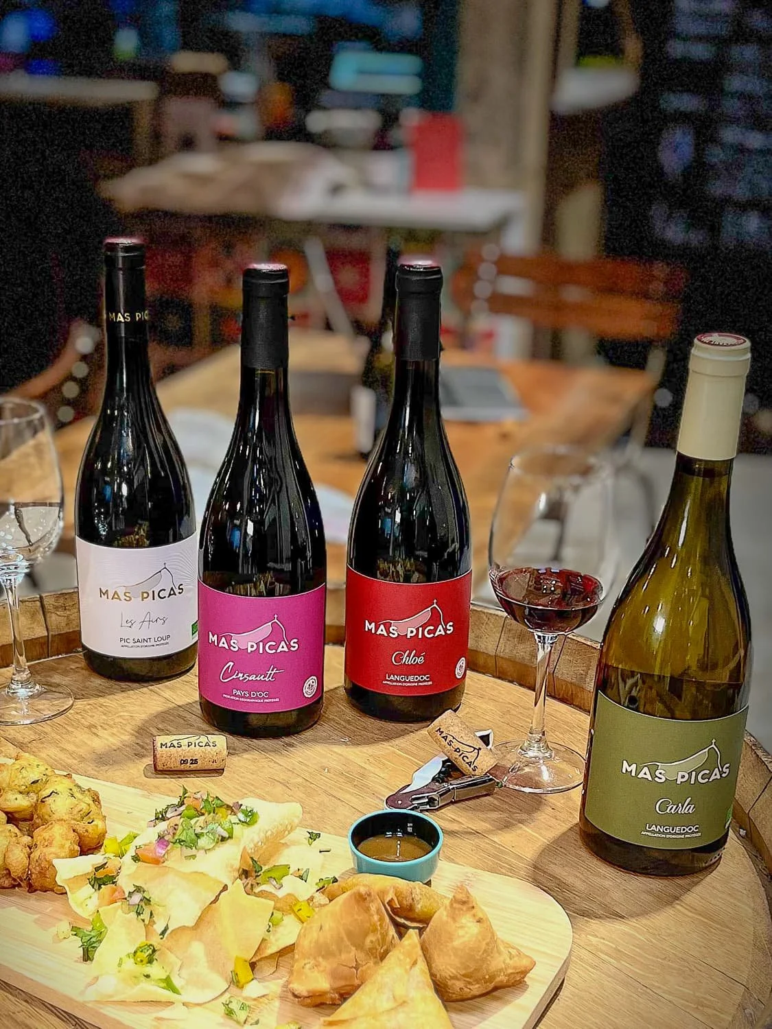 Photographie culinaire mettant en valeur les vins Mas Picas et une planche apéritive dans un restaurant, réalisée pour illustrer la communication visuelle et l’identité d’un lieu.