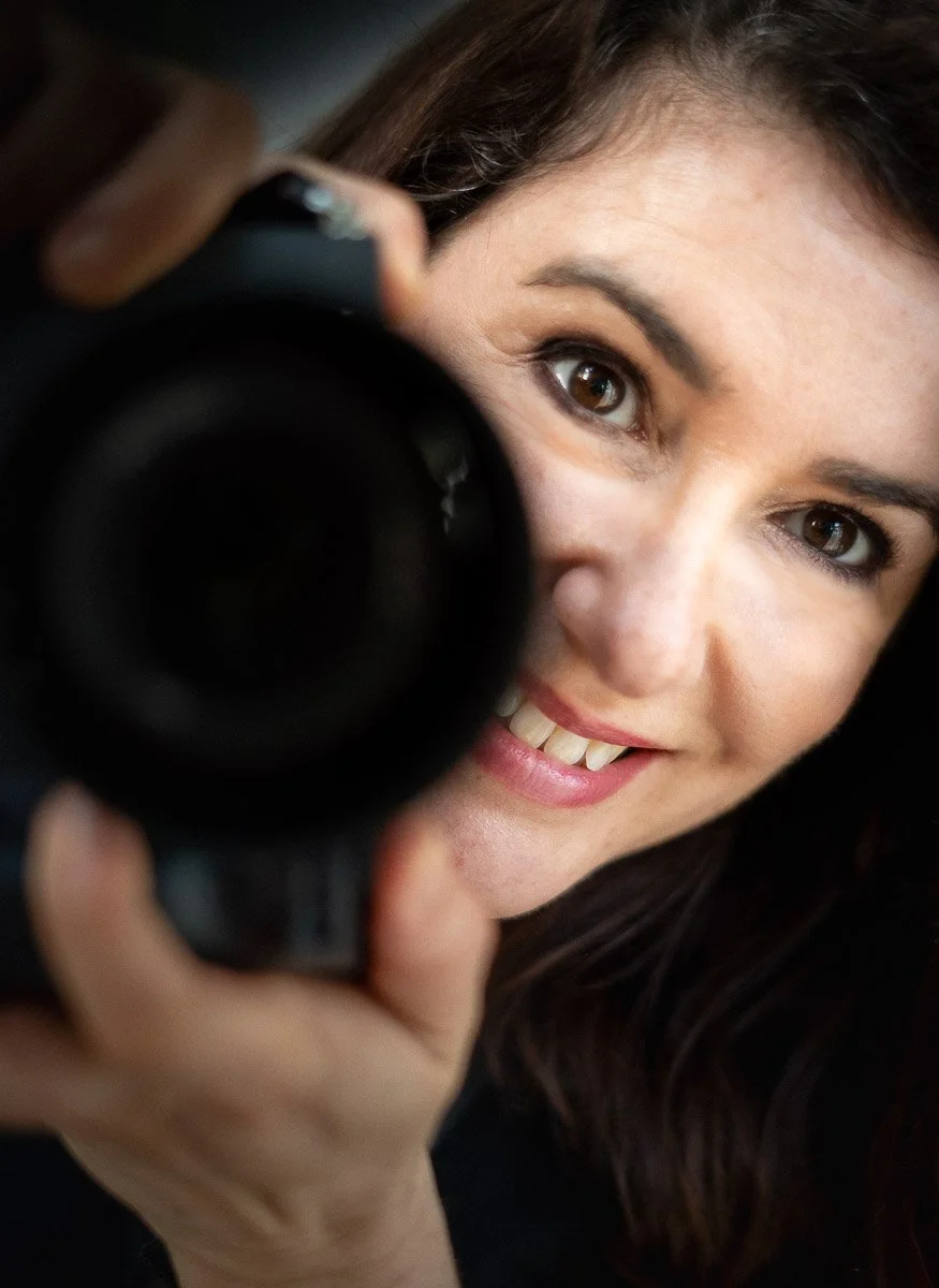 Photo de profil vue de face Nathalie Watrin avec objectif en main d'appareil photo pour l'aide et la création de contenu sur les réseaux sociaux