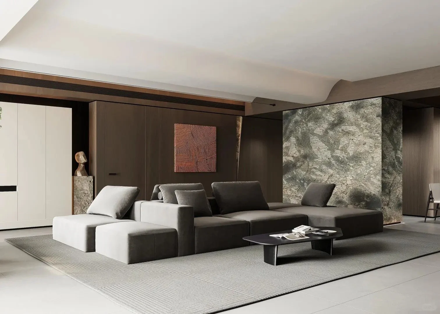 Modern living room with a gray sectional sofa, black coffee table, textured rug, artwork on the wall, and decorative sculpture on a pedestal.