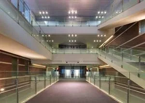 Interior view of a modern, multi-level building with glass railings and escalators.