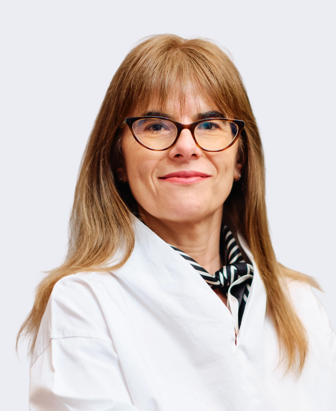 A woman with shoulder-length light brown hair, glasses, and a white coat, smiling against a plain background.