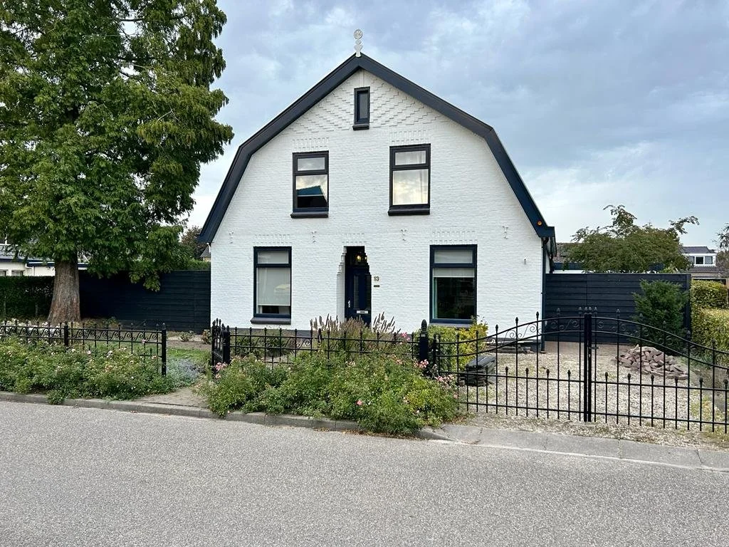 Een wit huis in Haaften met tuin en een smeedijzeren hek | Highstreet Heerewaarden