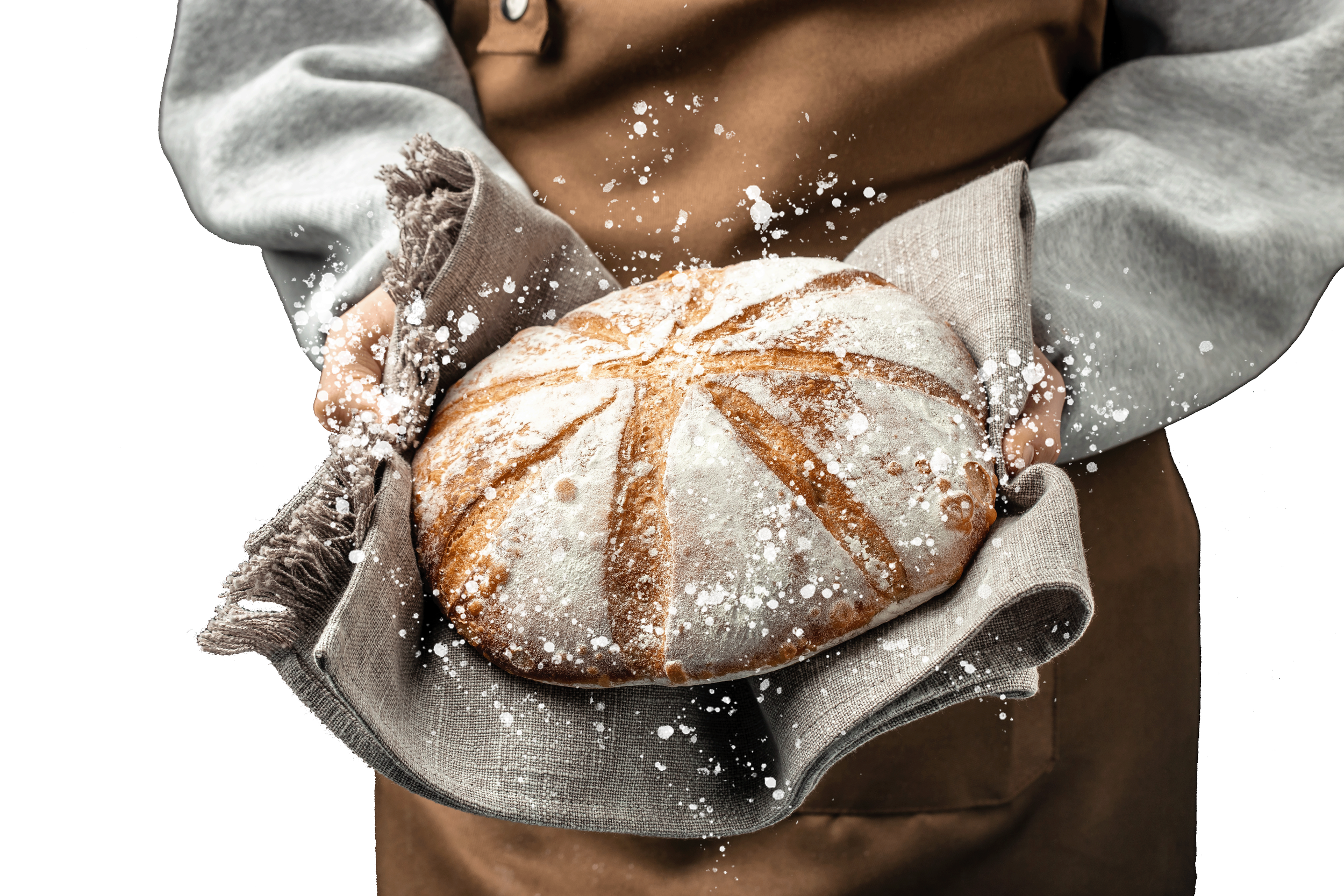 A person holding a round loaf of bread dusted with flour, with a background of a brown sofa or cushion, wearing a gray sweatshirt with frayed edges.