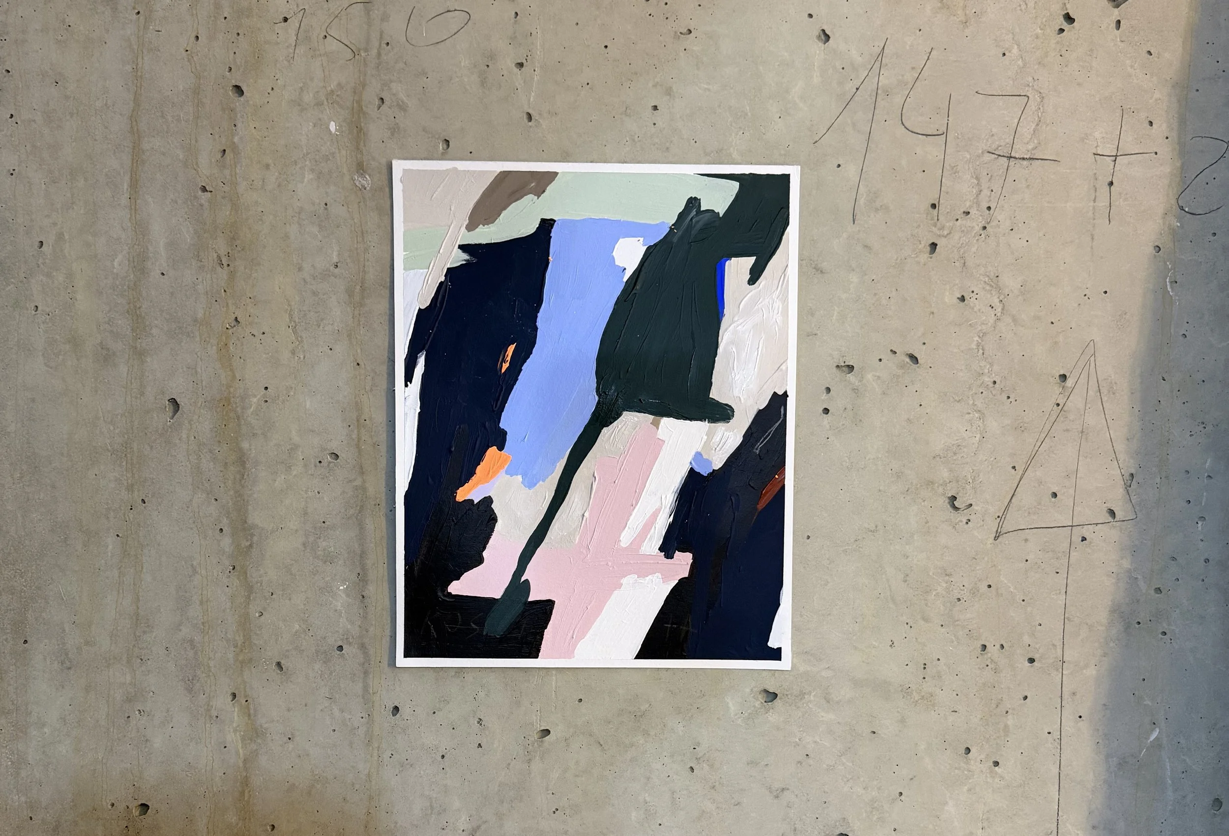 An abstract painting on paper featuring bold, thick brushstrokes in black, blue, pink, beige, white, and orange, displayed against a concrete wall with scribbles and markings by Aura Delamotte