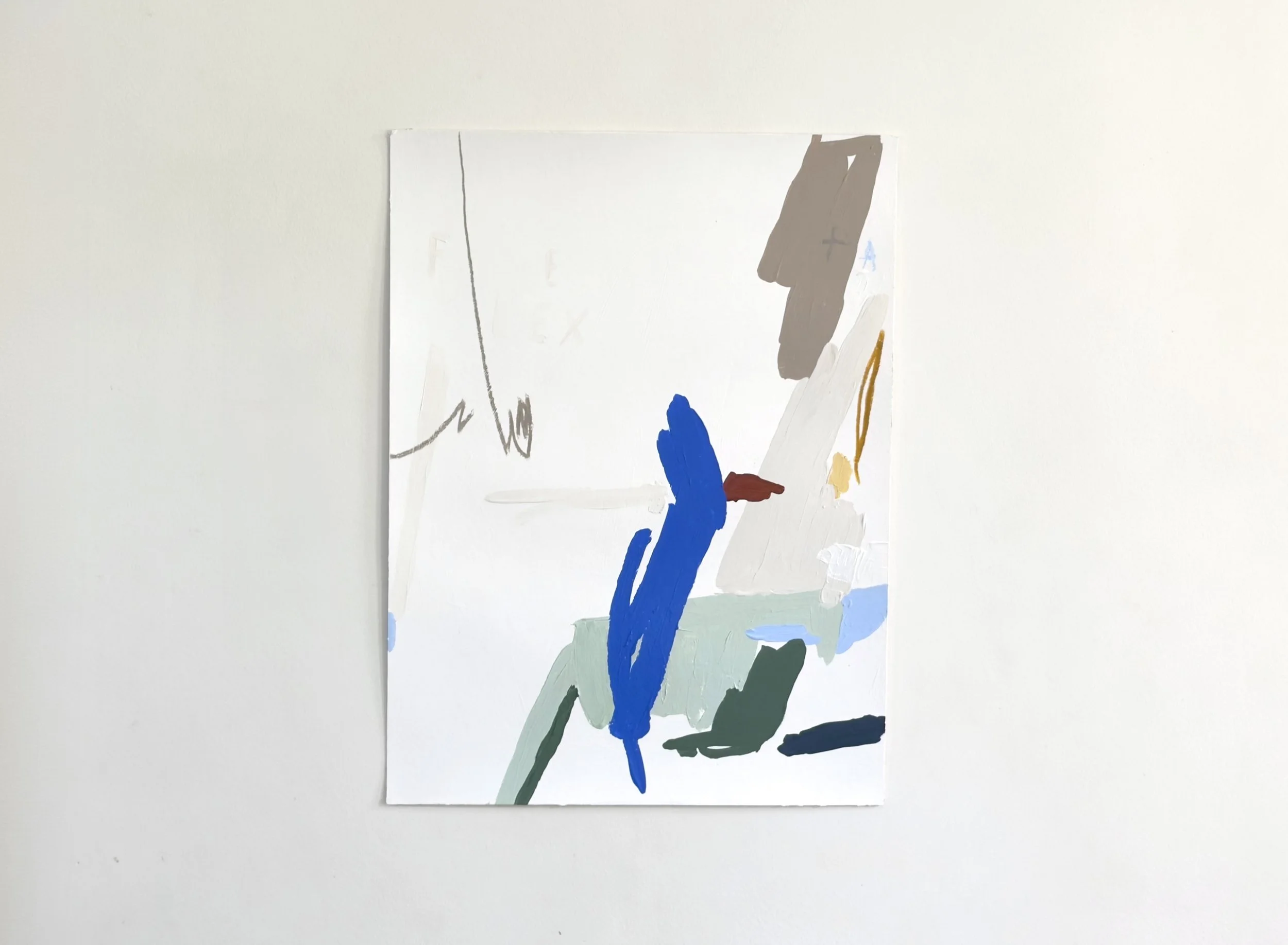 Abstract minimalist painting with brushstrokes in blue, brown, black, white, light gray, and beige on a white canvas, leaning against a plain white wall by Aura Delamotte.