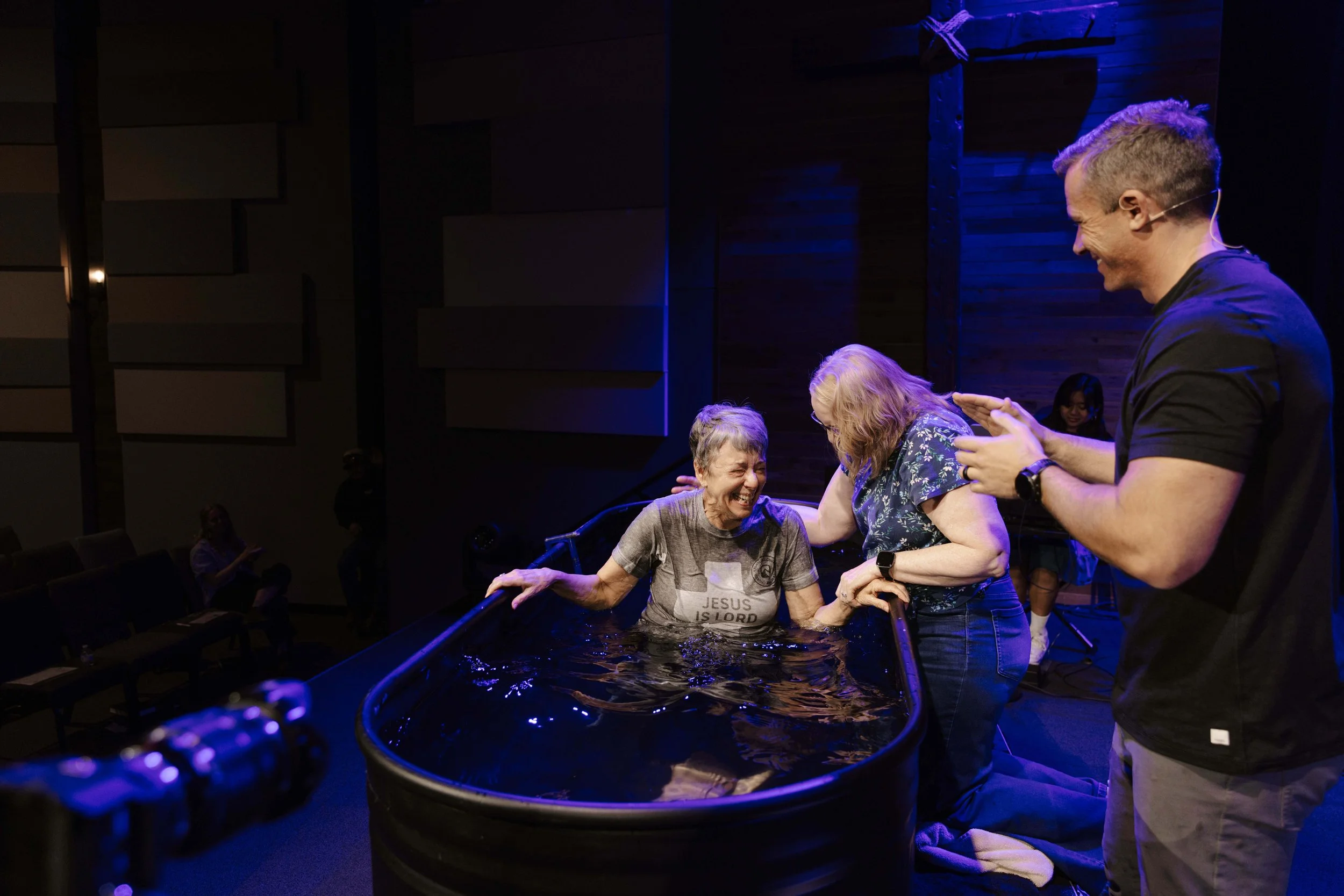 A middle aged woman getting baptized. 