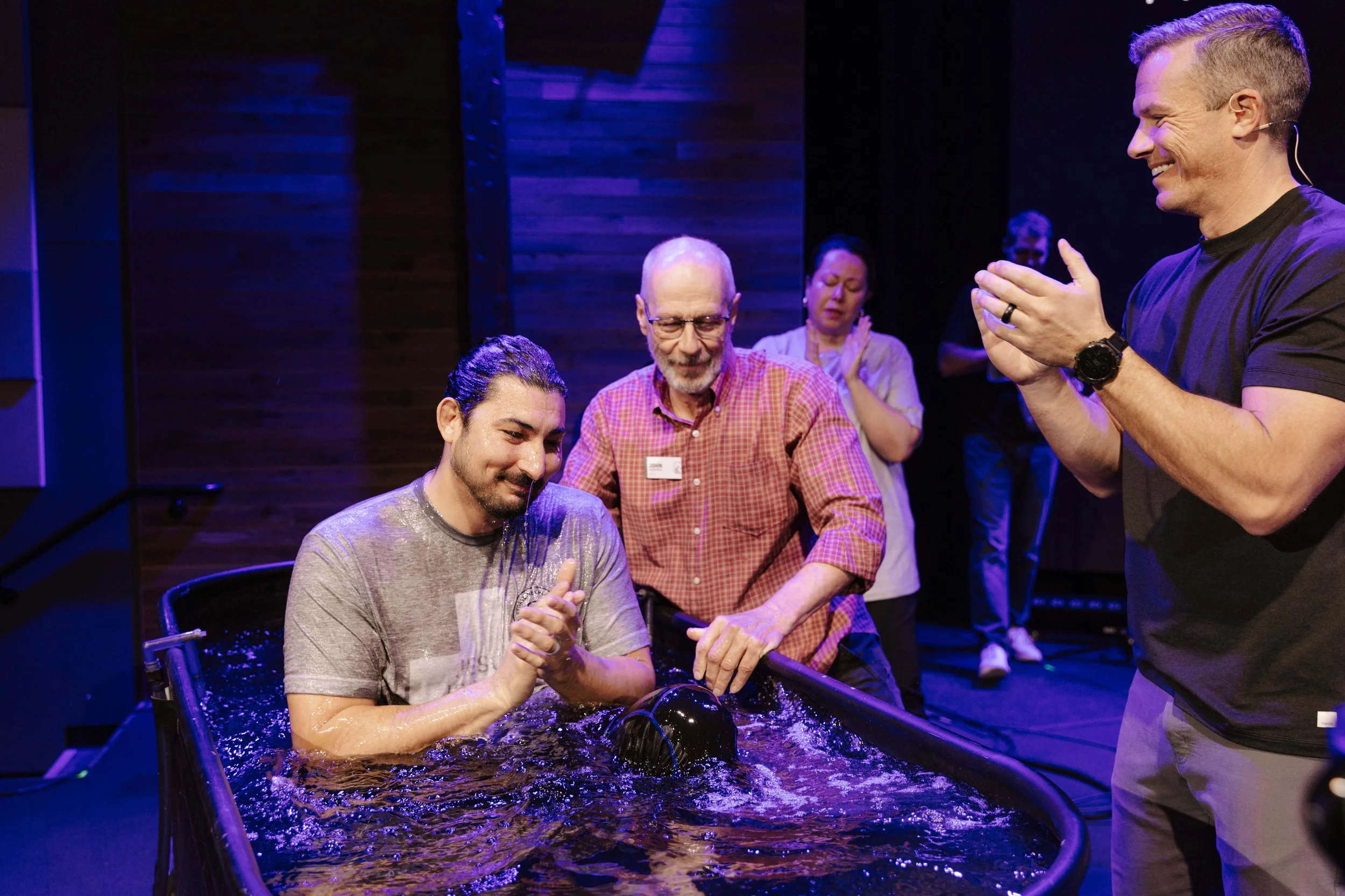 A young man getting baptized by an elder at storyline church.