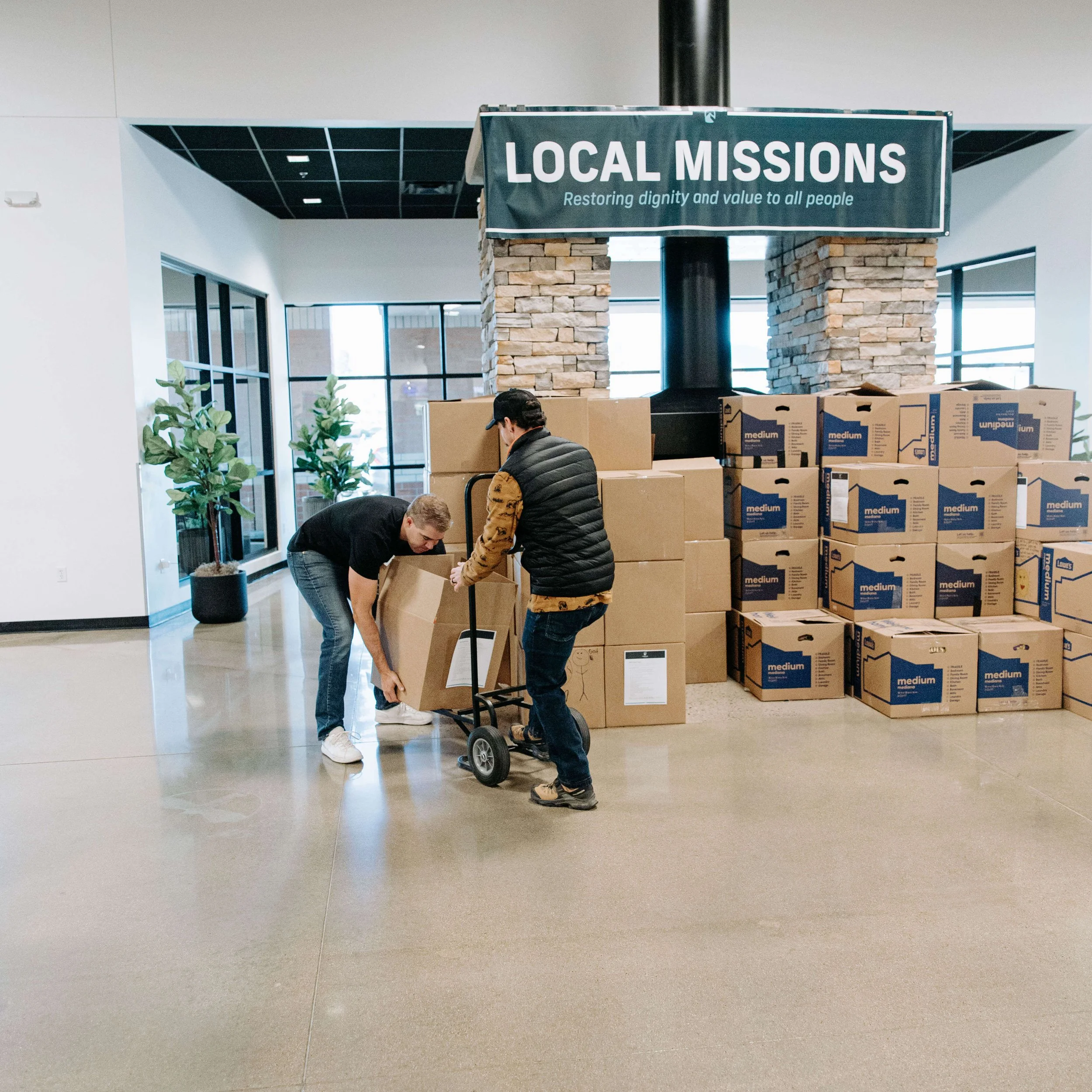 A man with a dolly collects boxes full of food for donations to local partners.