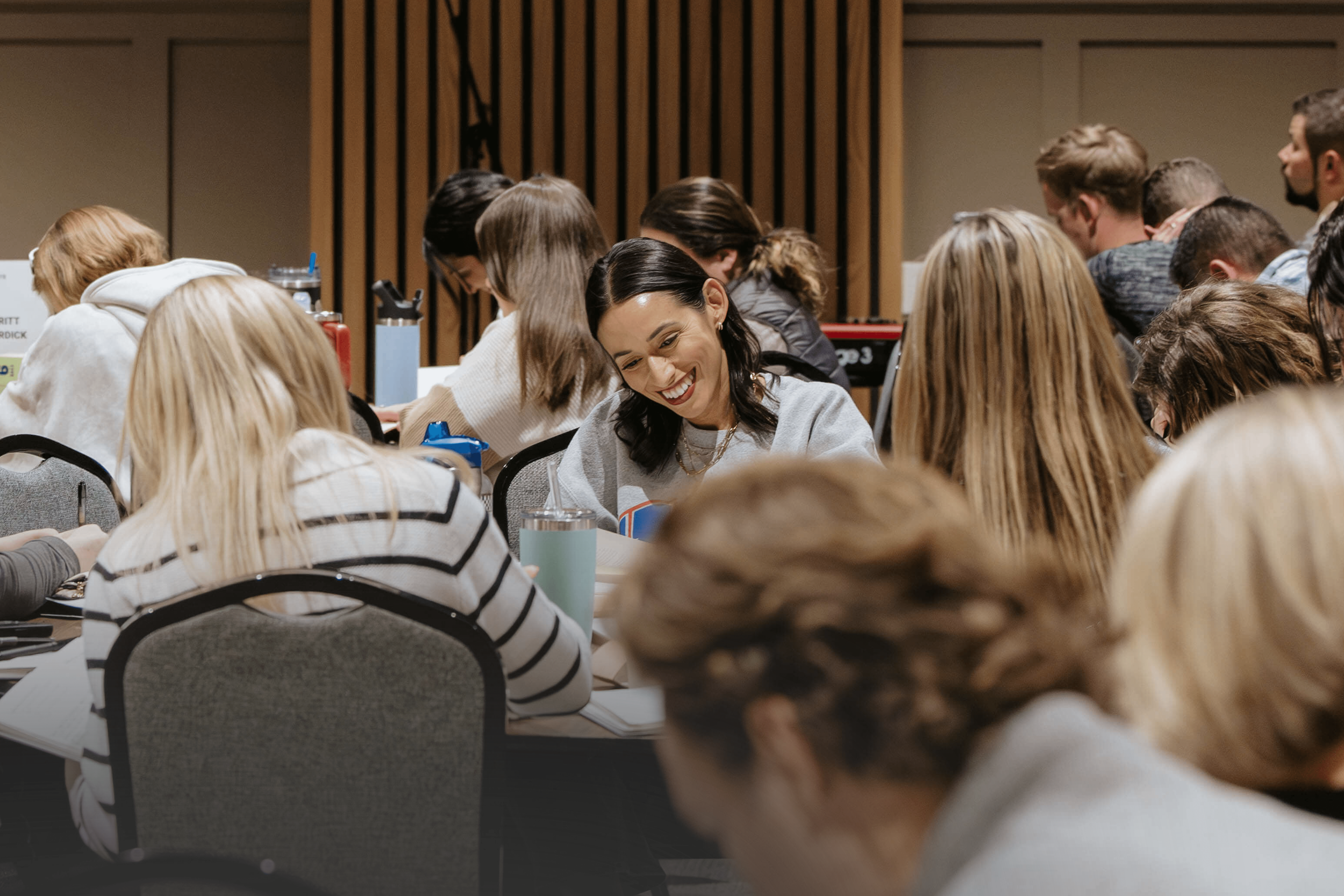A woman writing in her bible at a discipleship event.